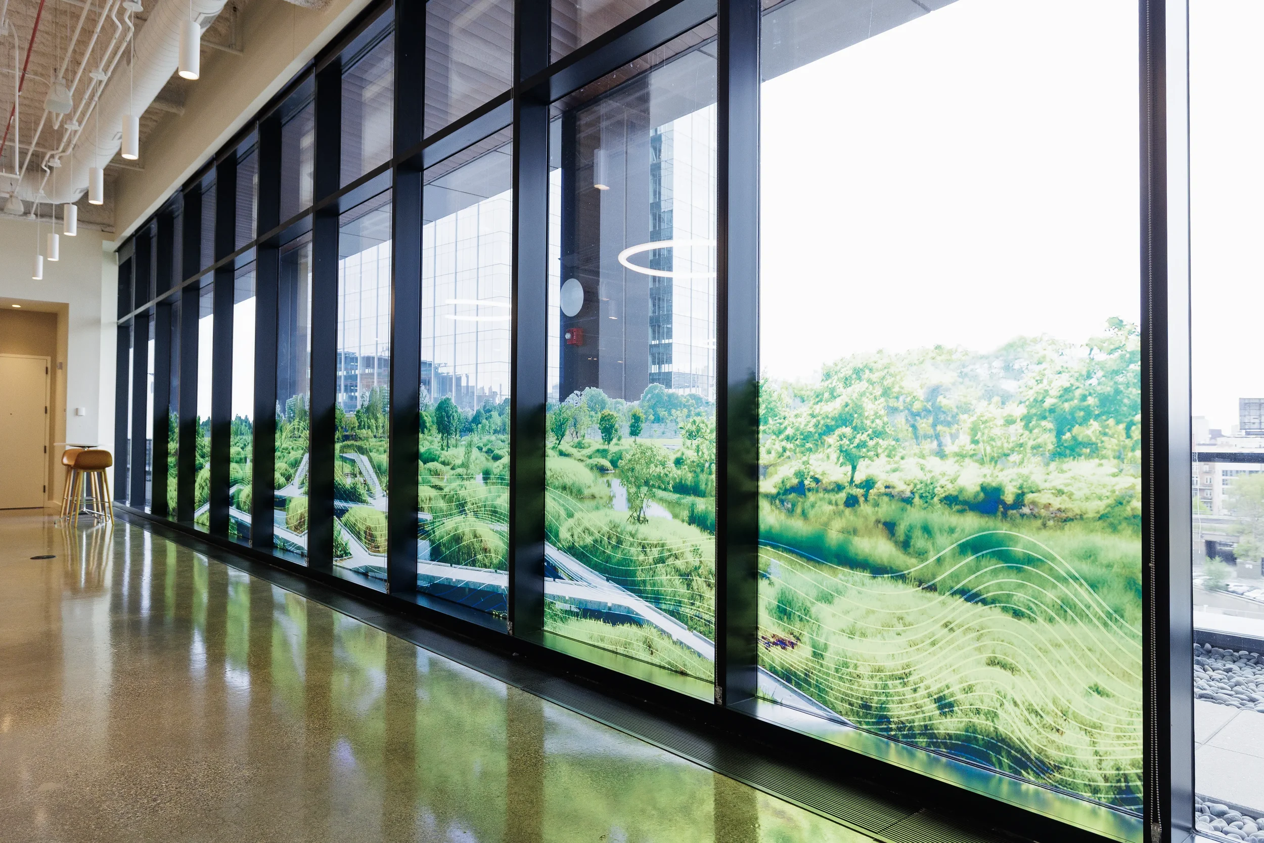 Floor-to-ceiling windows with green landscape graphics in event venue hallway in Chicago