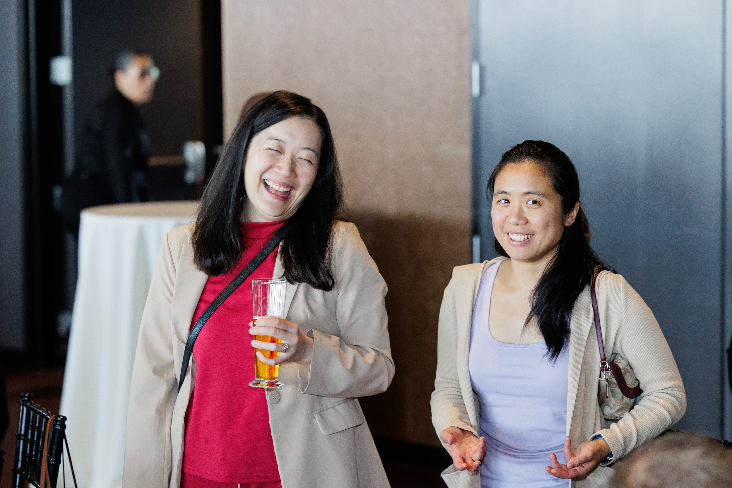 Two attendees laugh together with a beer during networking reception at Orlando corporate event