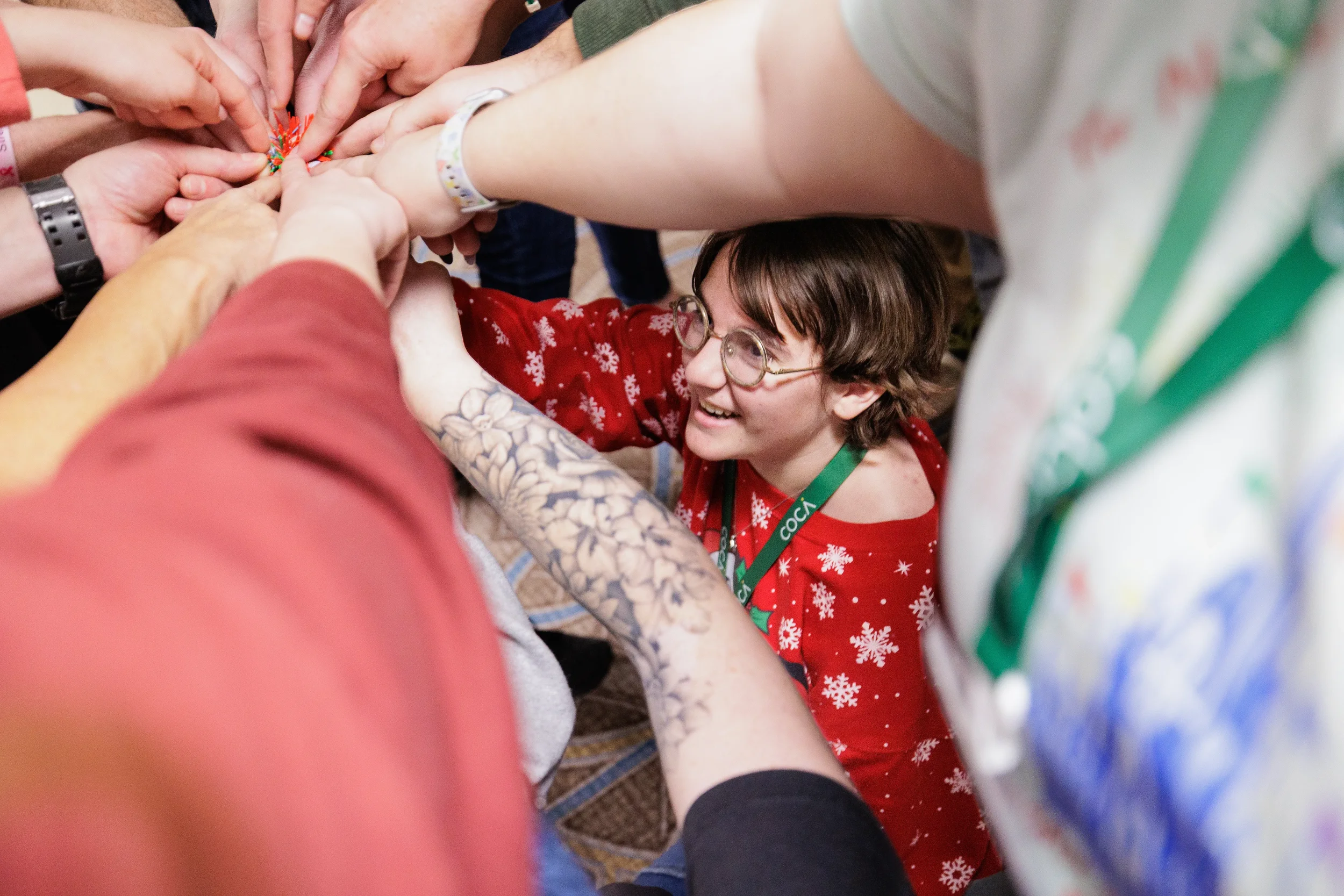 Smiling attendee wearing COCA lanyard joins group hands-in huddle at Chicago nonprofit conference event