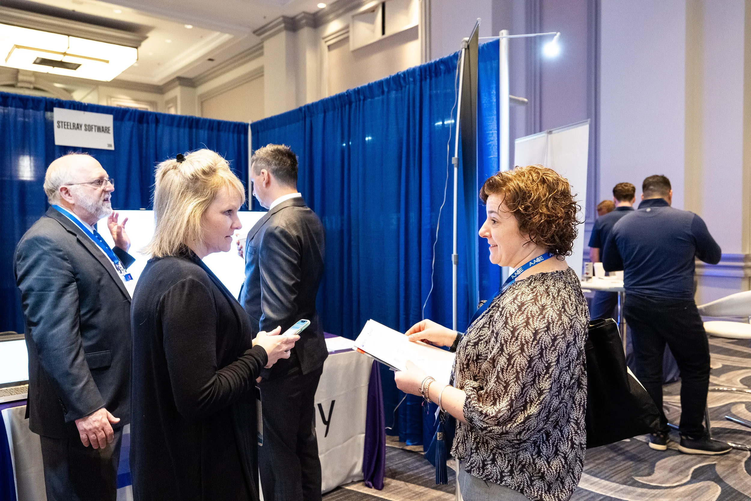 Attendees network near exhibitor booths on trade show floor at AACE International 2024 in Chicago