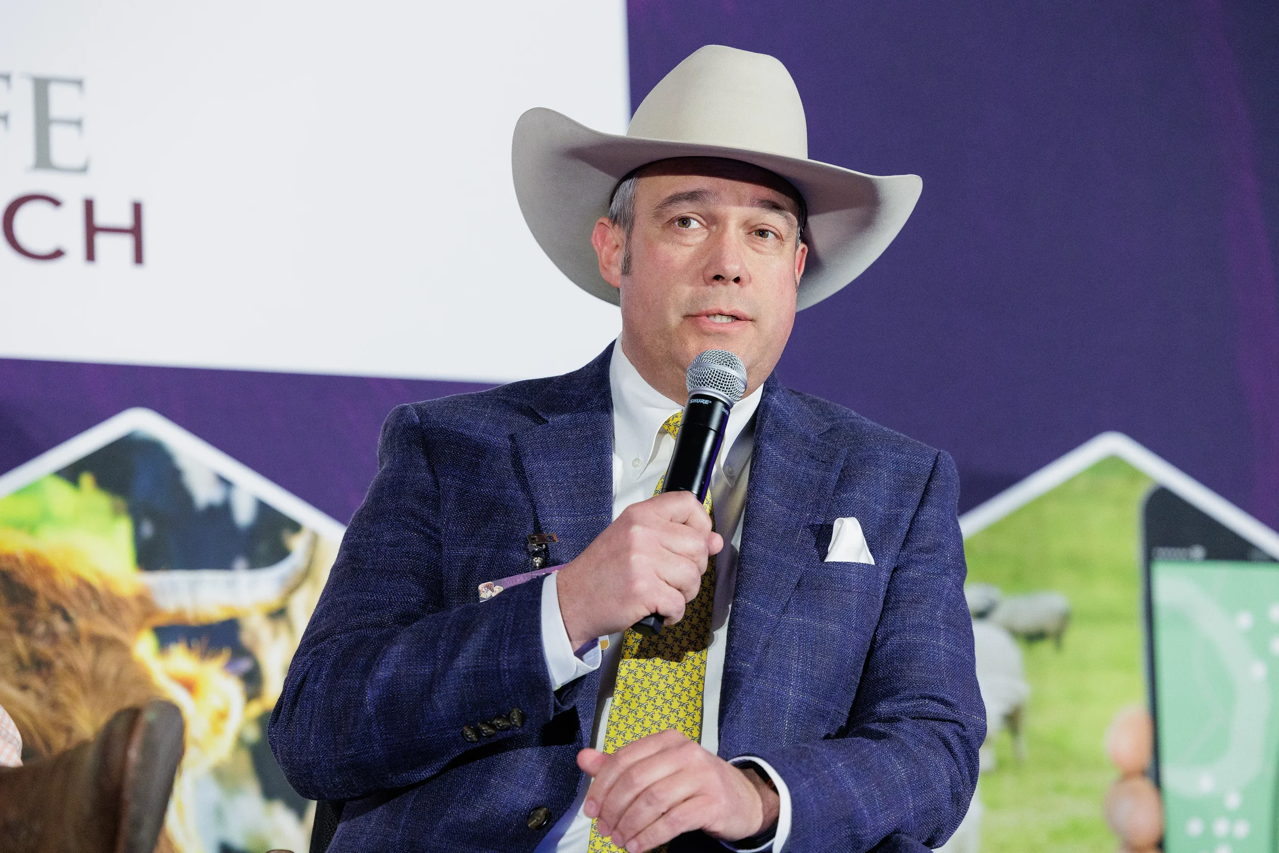Panelist wearing cowboy hat speaks into microphone during seated discussion at Chicago industry summit