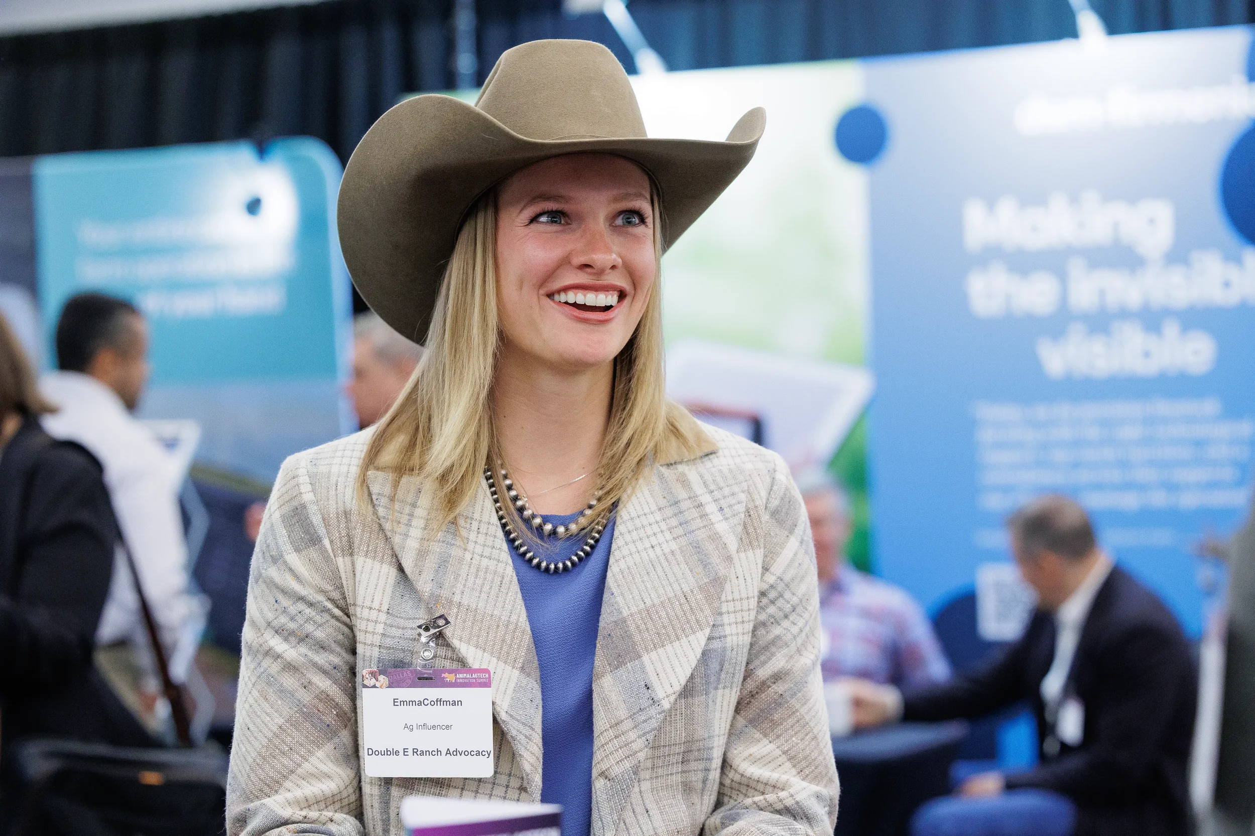 Attendee in cowboy hat smiles on expo floor at Chicago industry conference