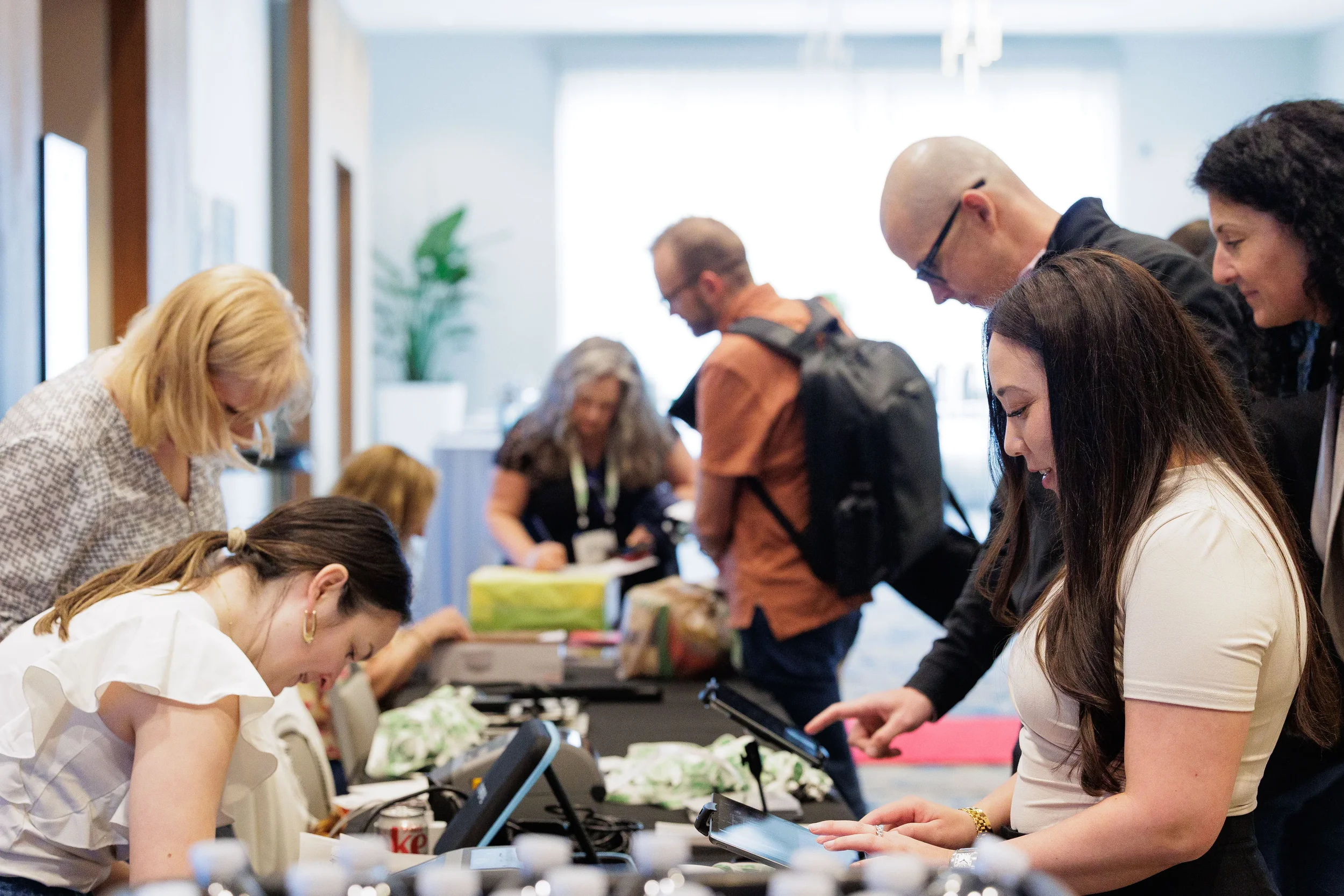 Attendees check in at registration table with tablets at Chicago corporate conference