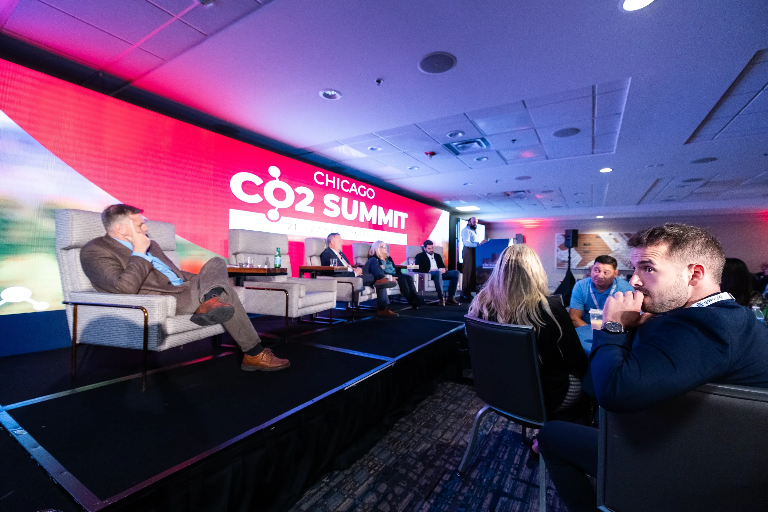 Attendee watches panelists discuss on stage during session at Orlando industry conference