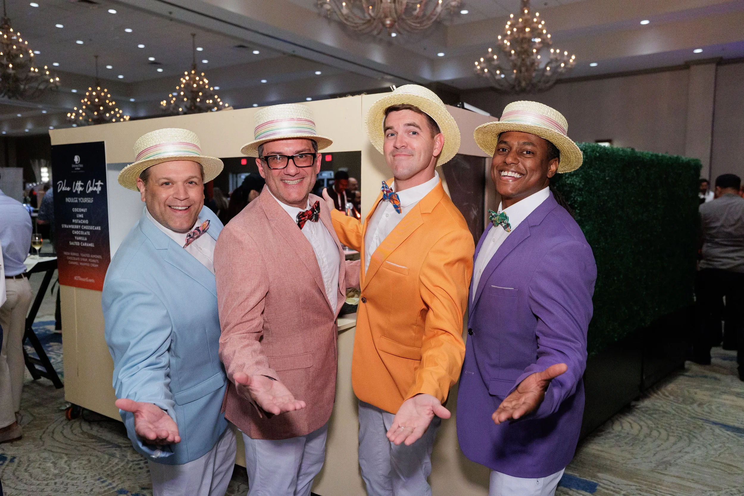 Four entertainers in colorful blazers and straw hats pose in ballroom at Chicago corporate event