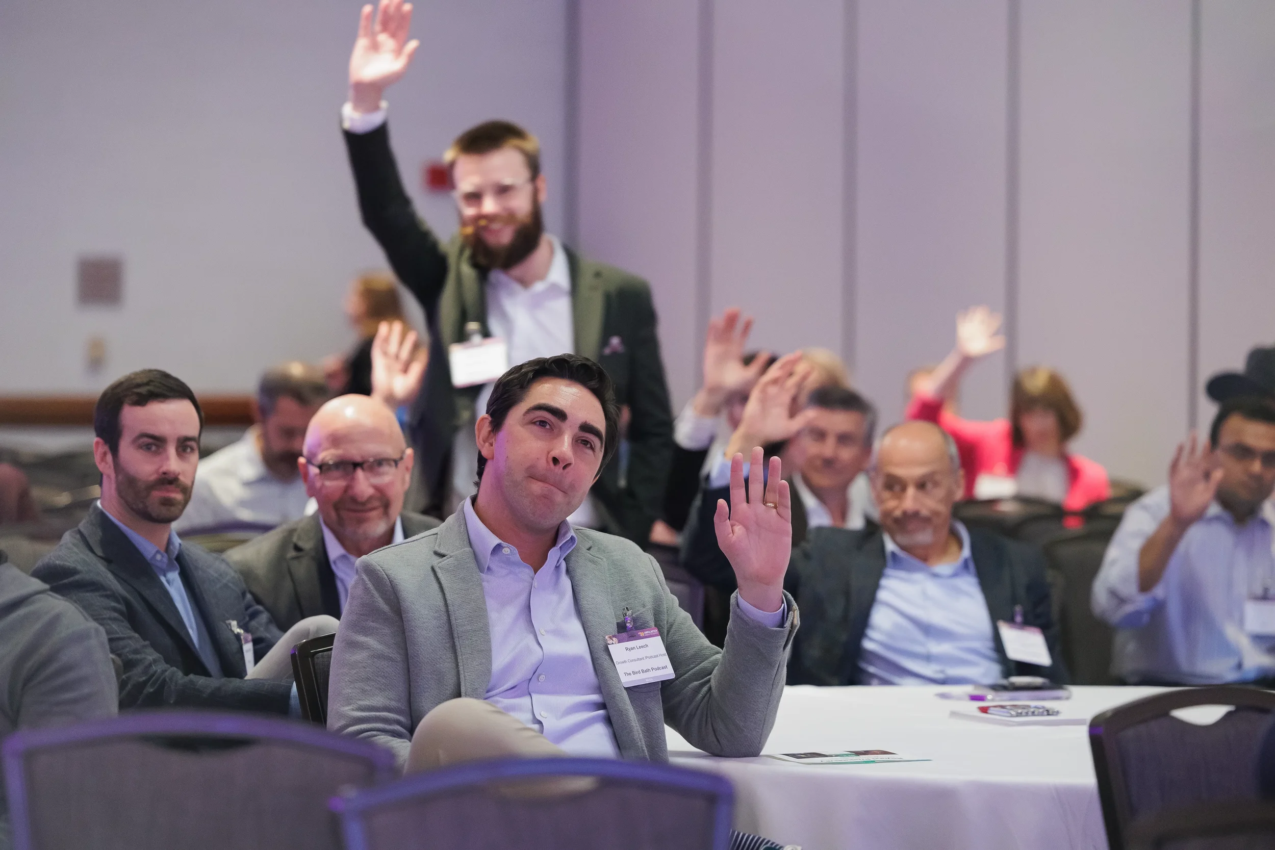 Attendees raise hands to respond during session at Orlando corporate conference
