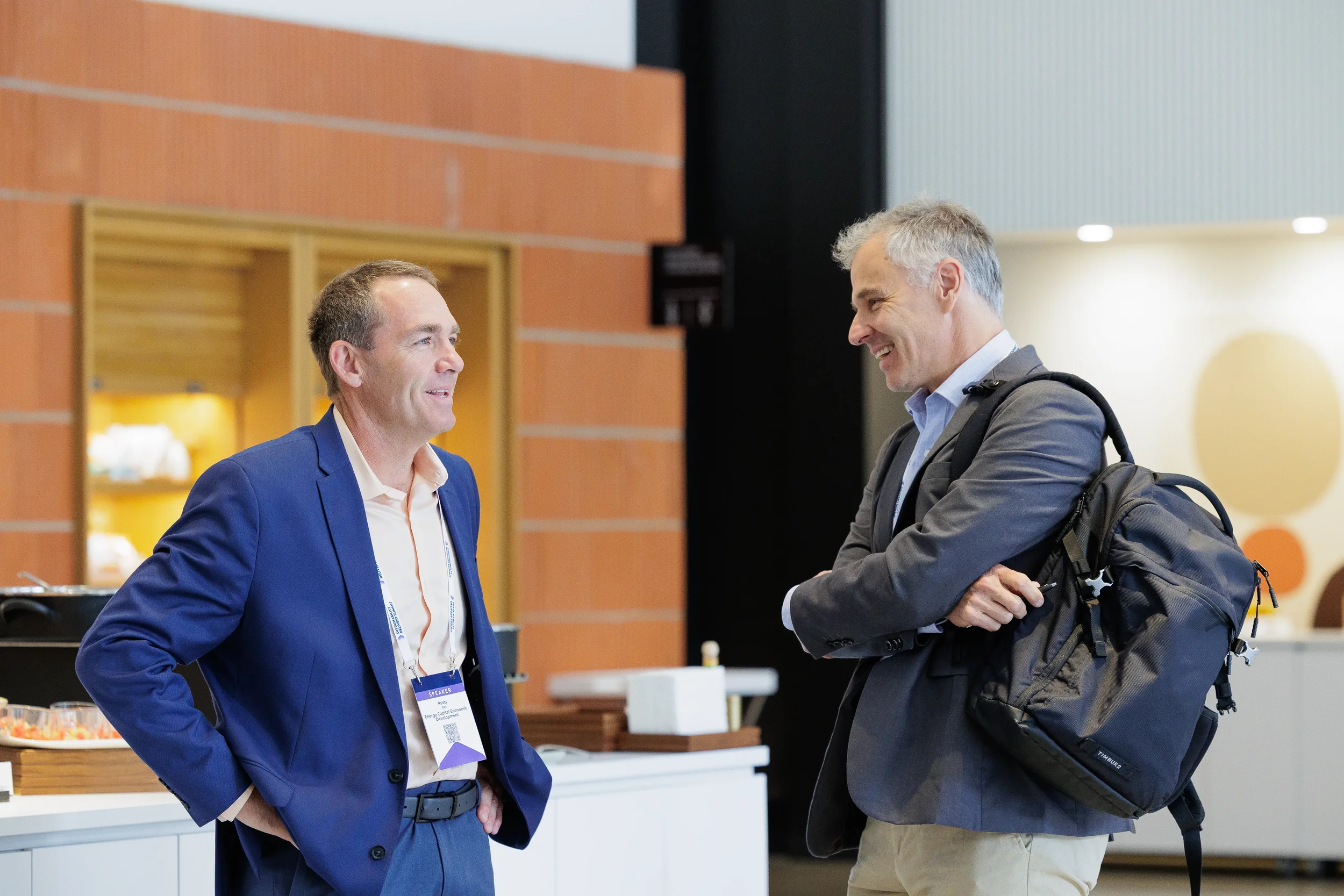 Two attendees laugh and converse in lobby during Chicago corporate conference event