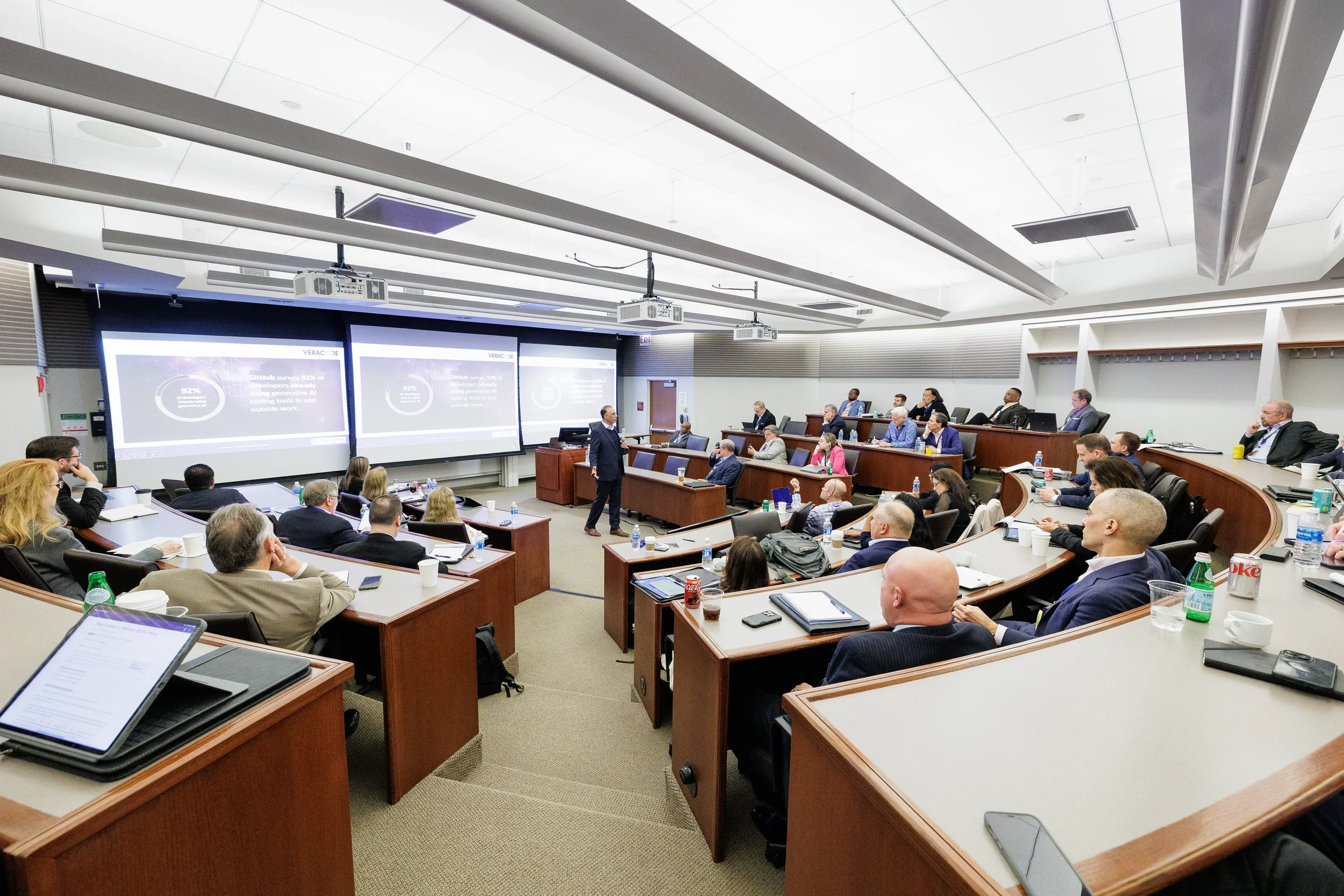 Attendees seated in tiered conference room watching dual projection screens at Chicago corporate event