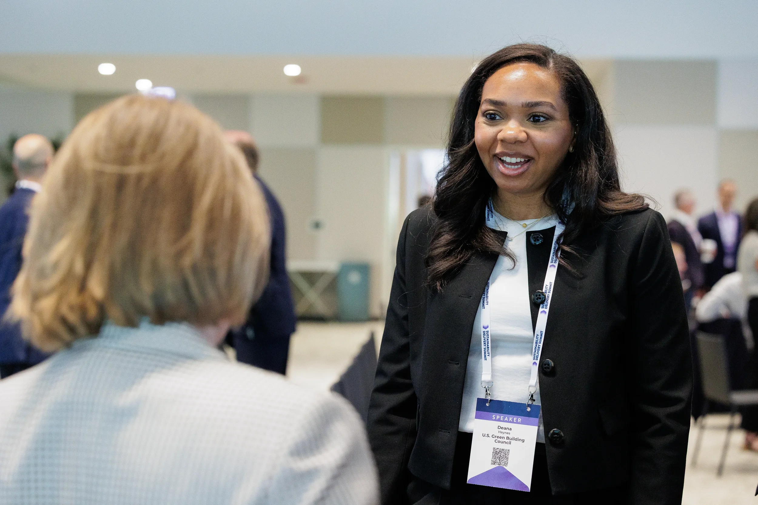 Speaker converses closely with attendee during networking moment at Orlando industry conference