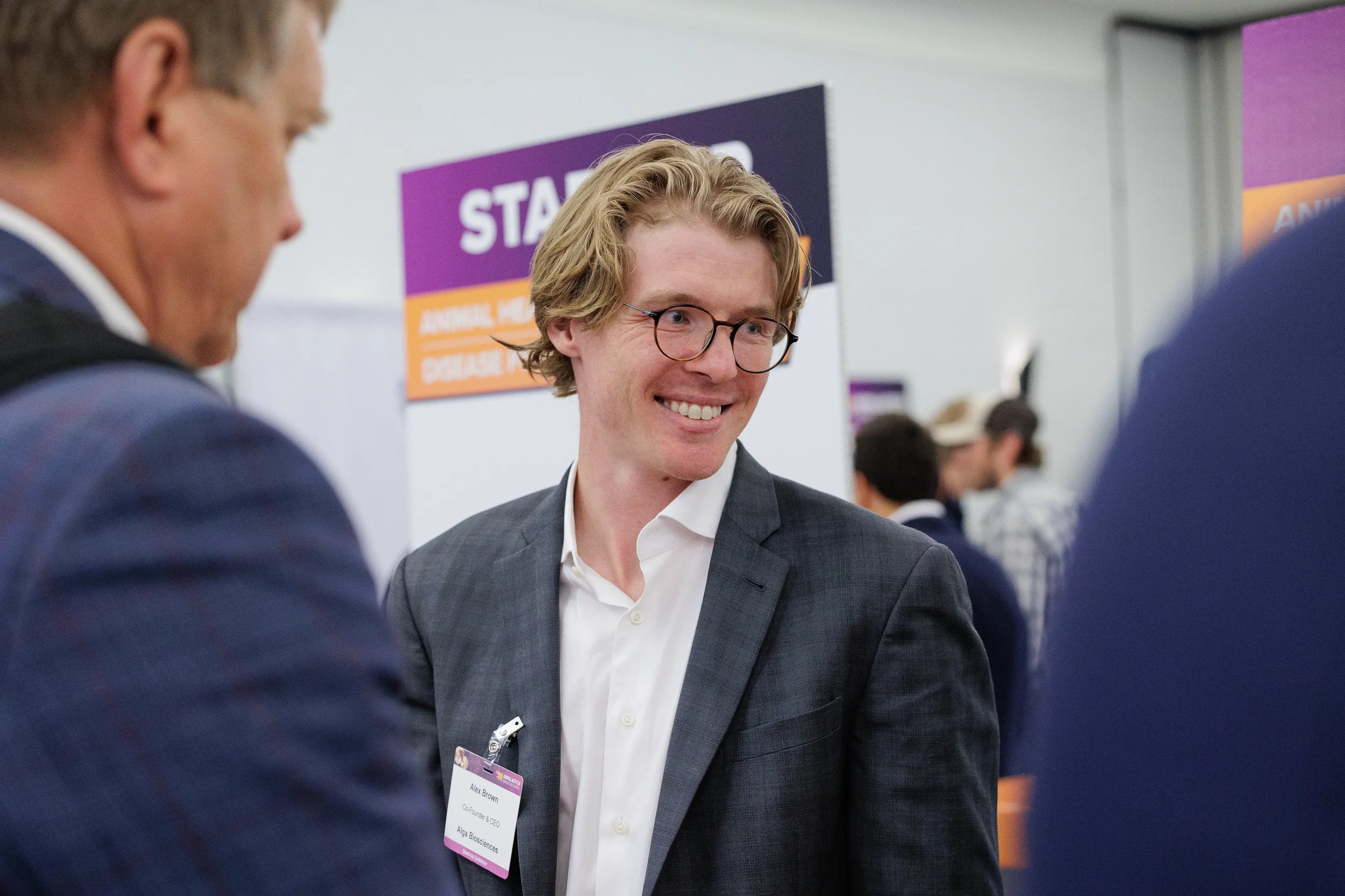 Attendees smile while conversing at startup expo booth during Chicago trade show