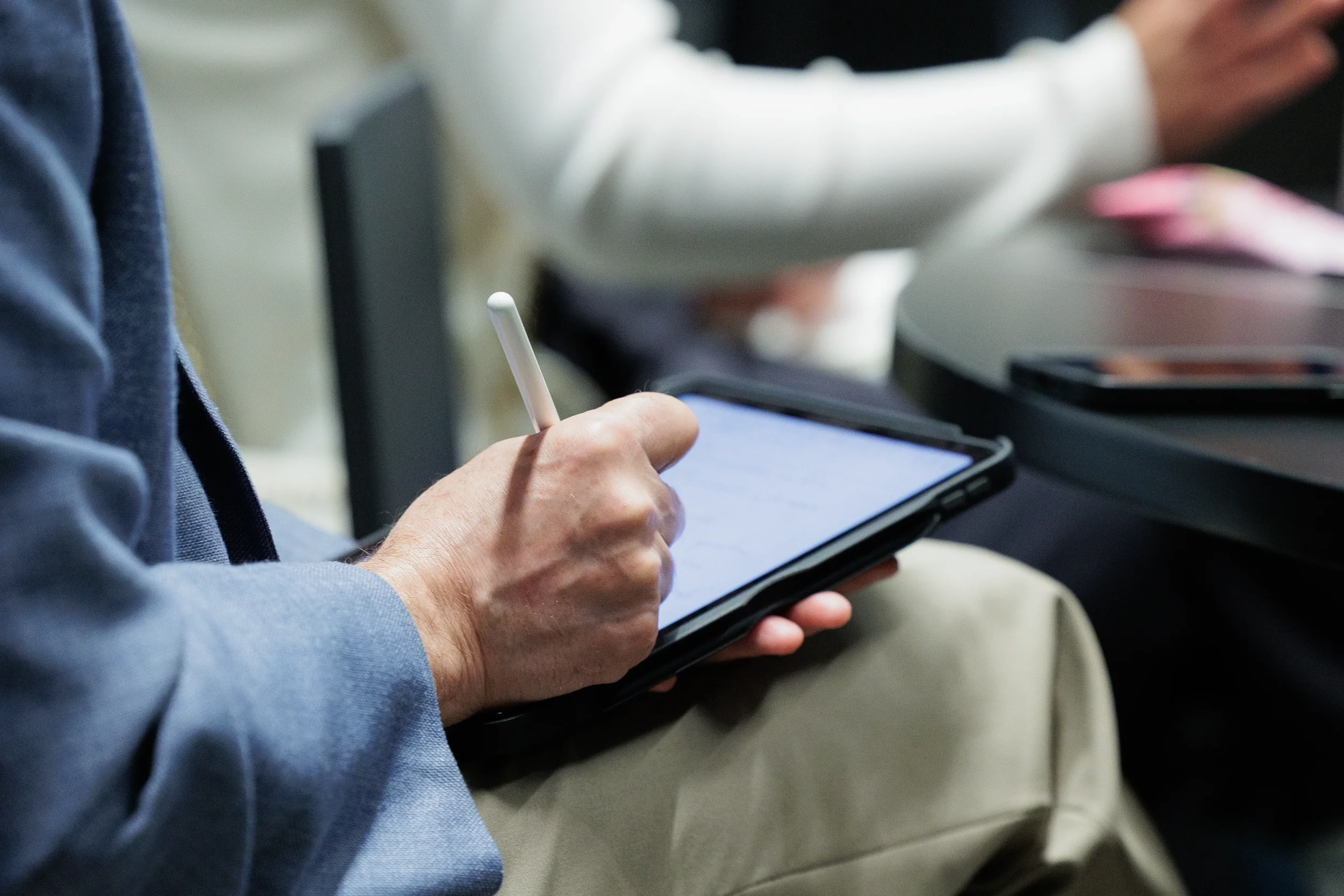 Attendee takes notes on tablet with stylus during Chicago industry conference session