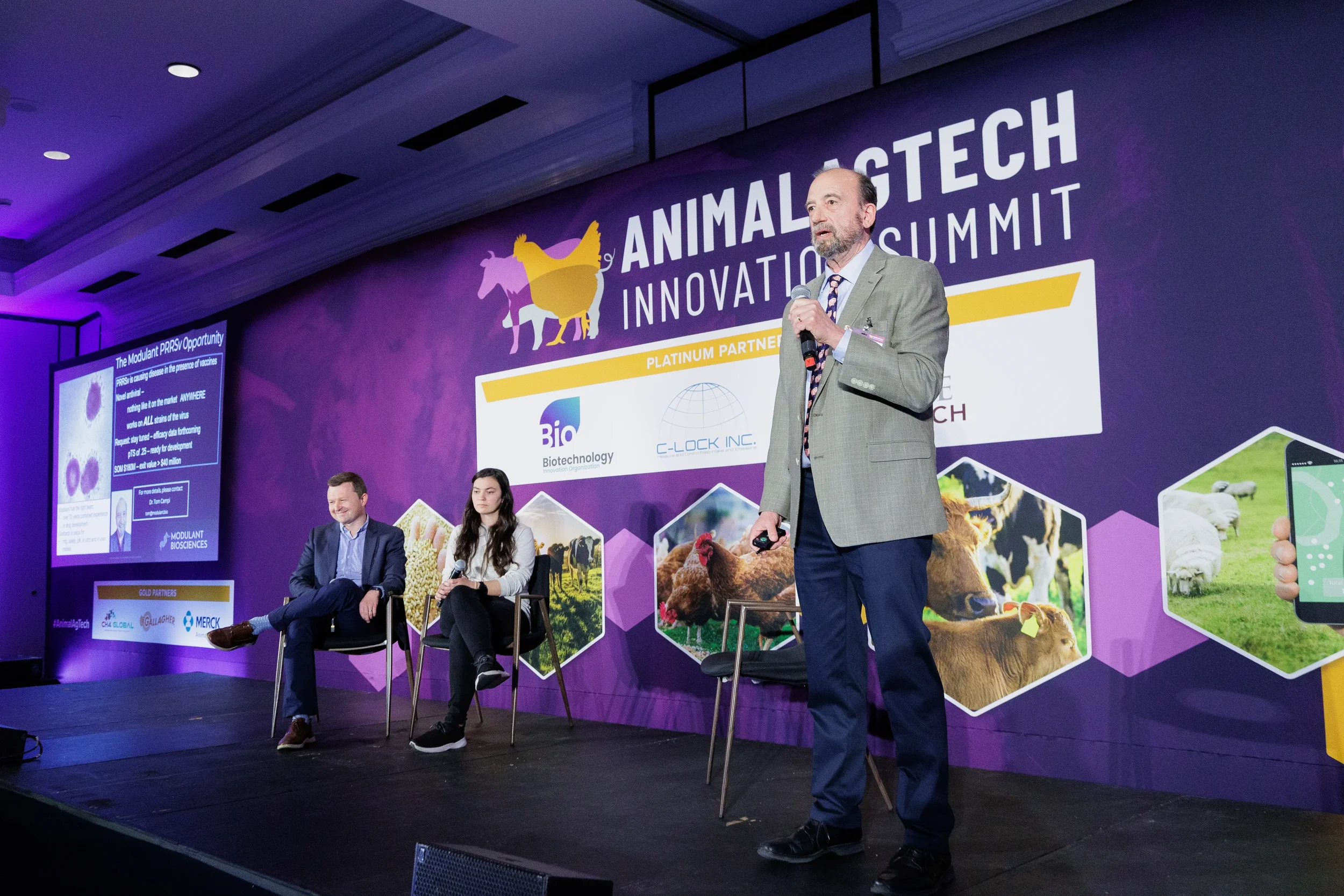 Speaker presents on stage before full event banner at Orlando corporate summit