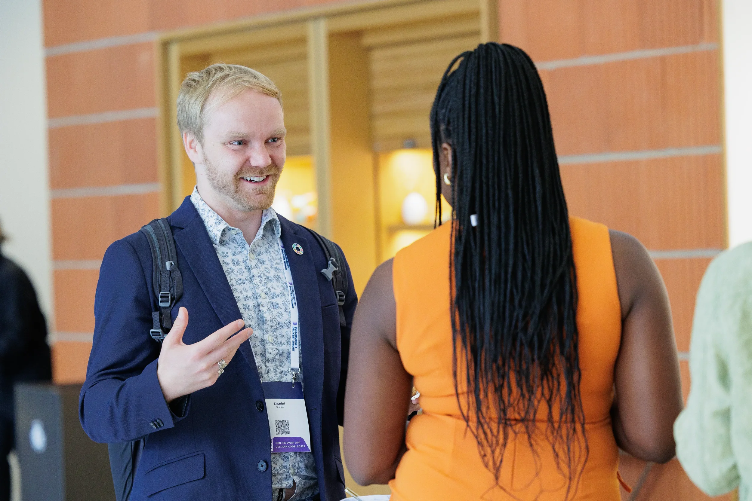 Attendees converse in hallway during break at Orlando industry conference