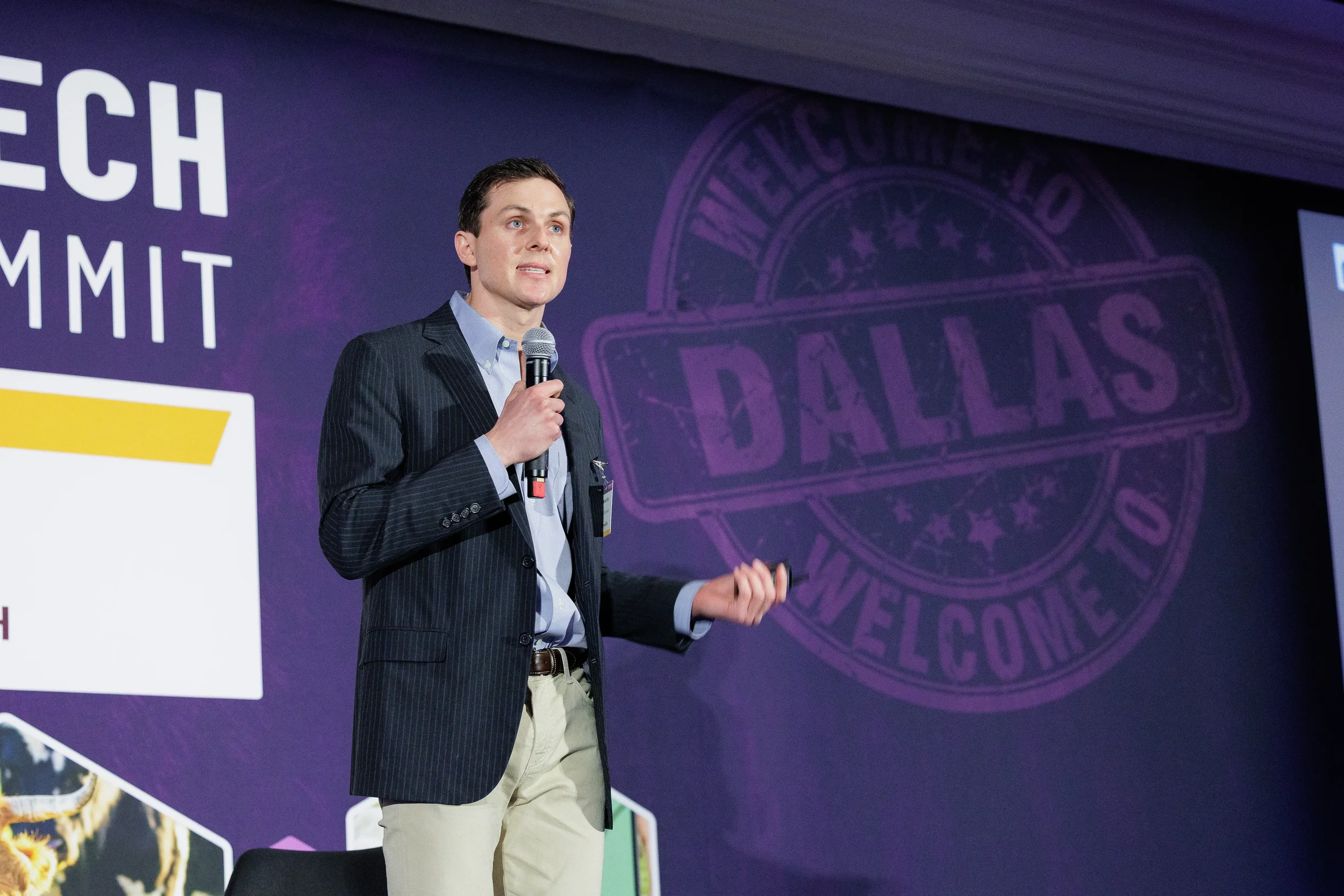Speaker presents on stage with microphone and clicker during Orlando corporate conference session