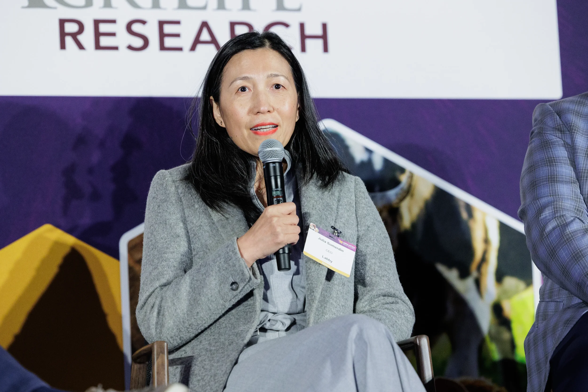 Speaker presents with microphone on branded stage at Chicago industry summit