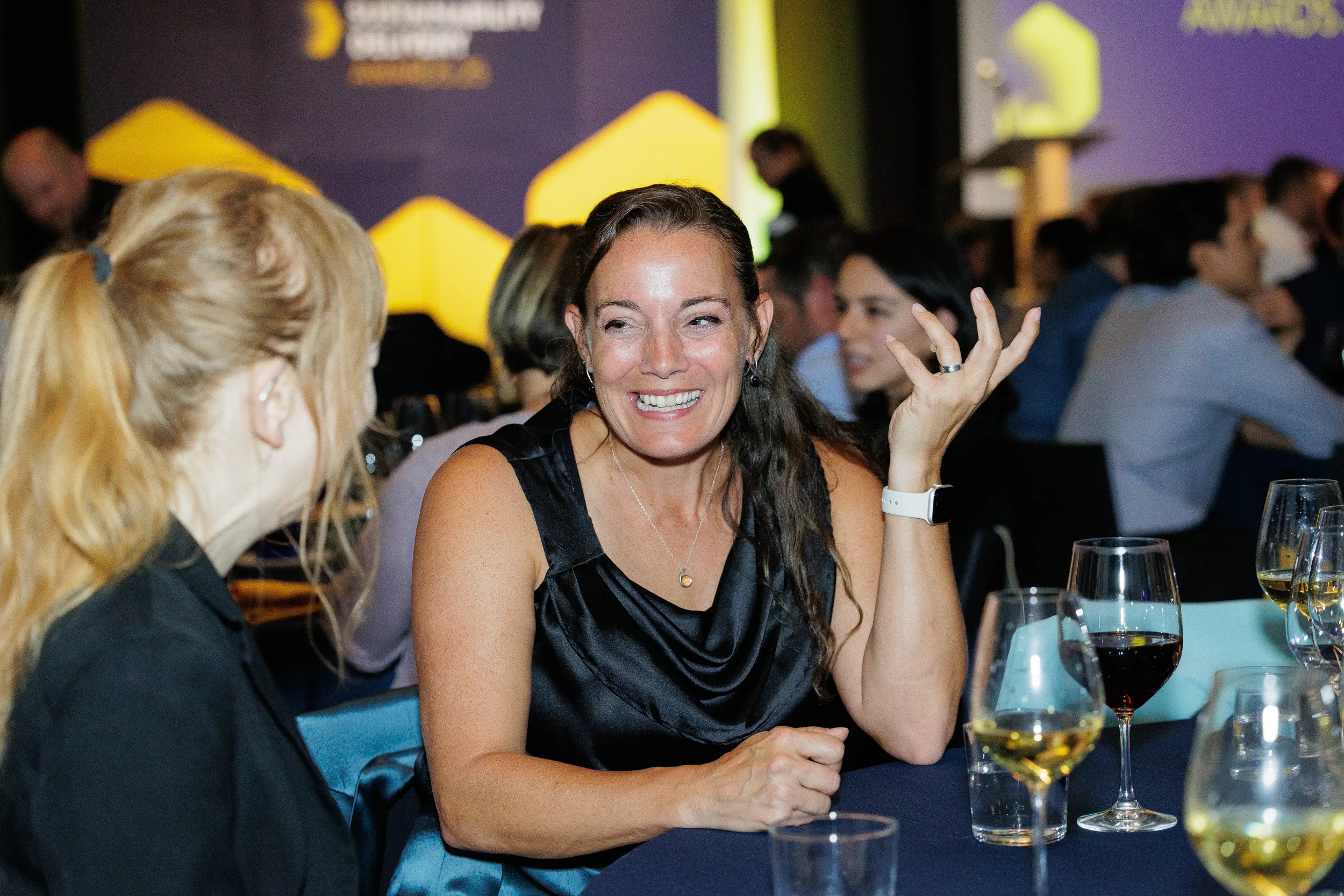 Attendee smiles while conversing with colleague at evening reception at Chicago corporate summit