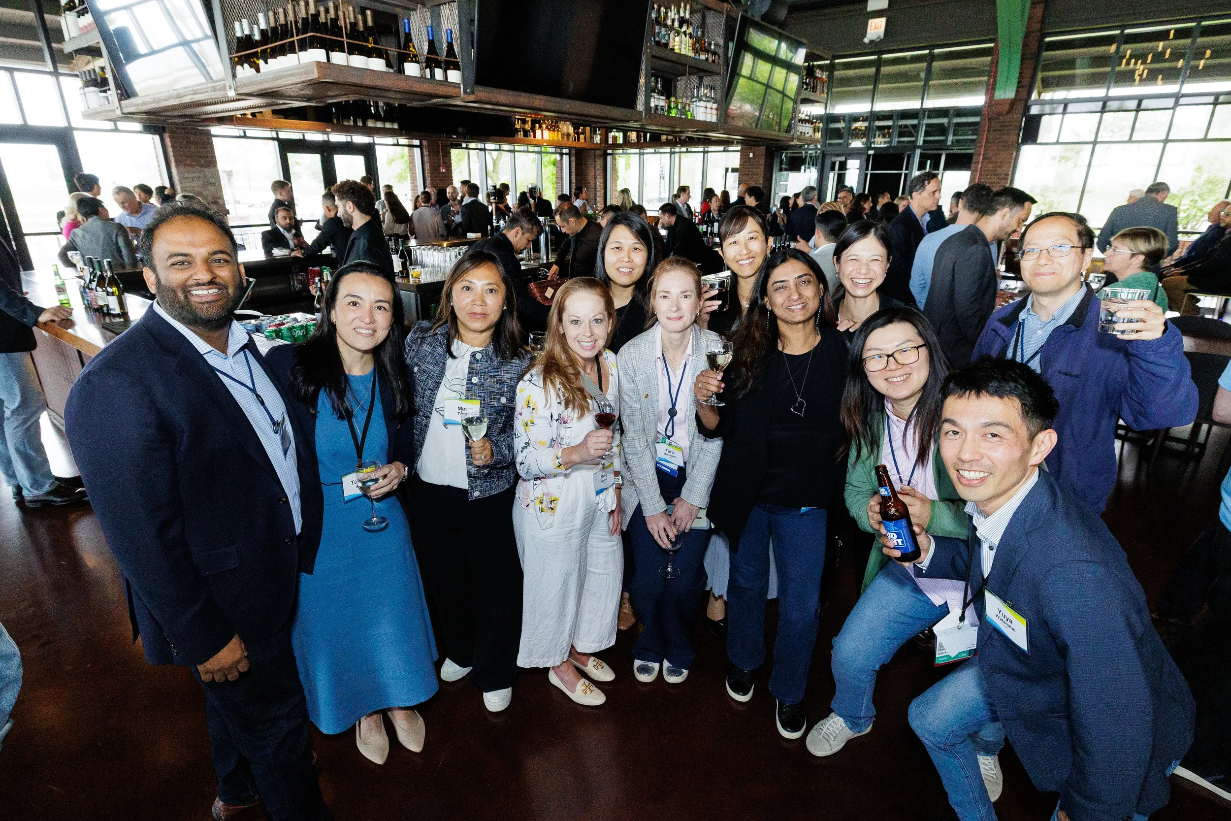 Large group of attendees pose together at bar reception during Orlando networking event