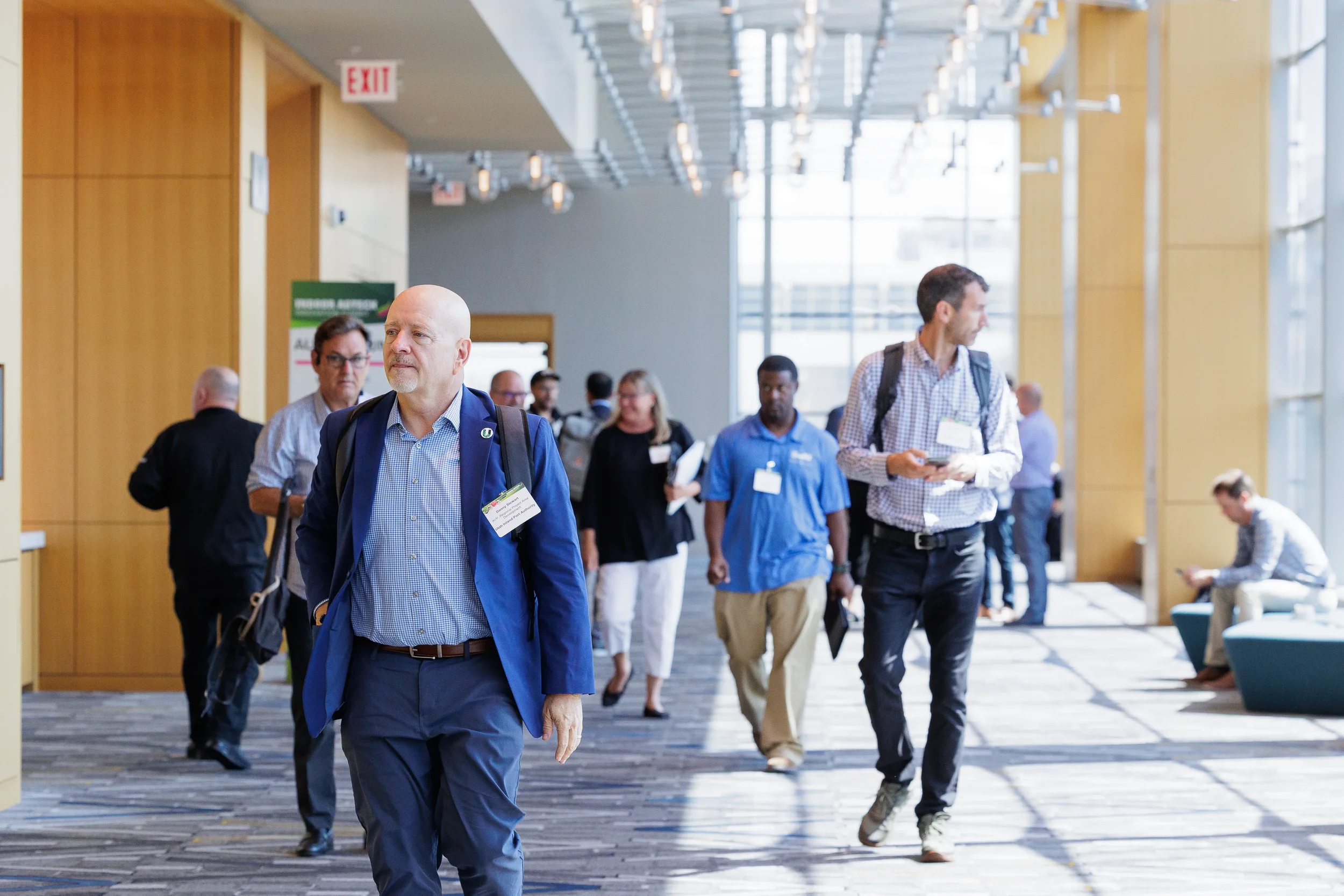 Conference attendees walk through bright convention center corridor between sessions at Orlando event