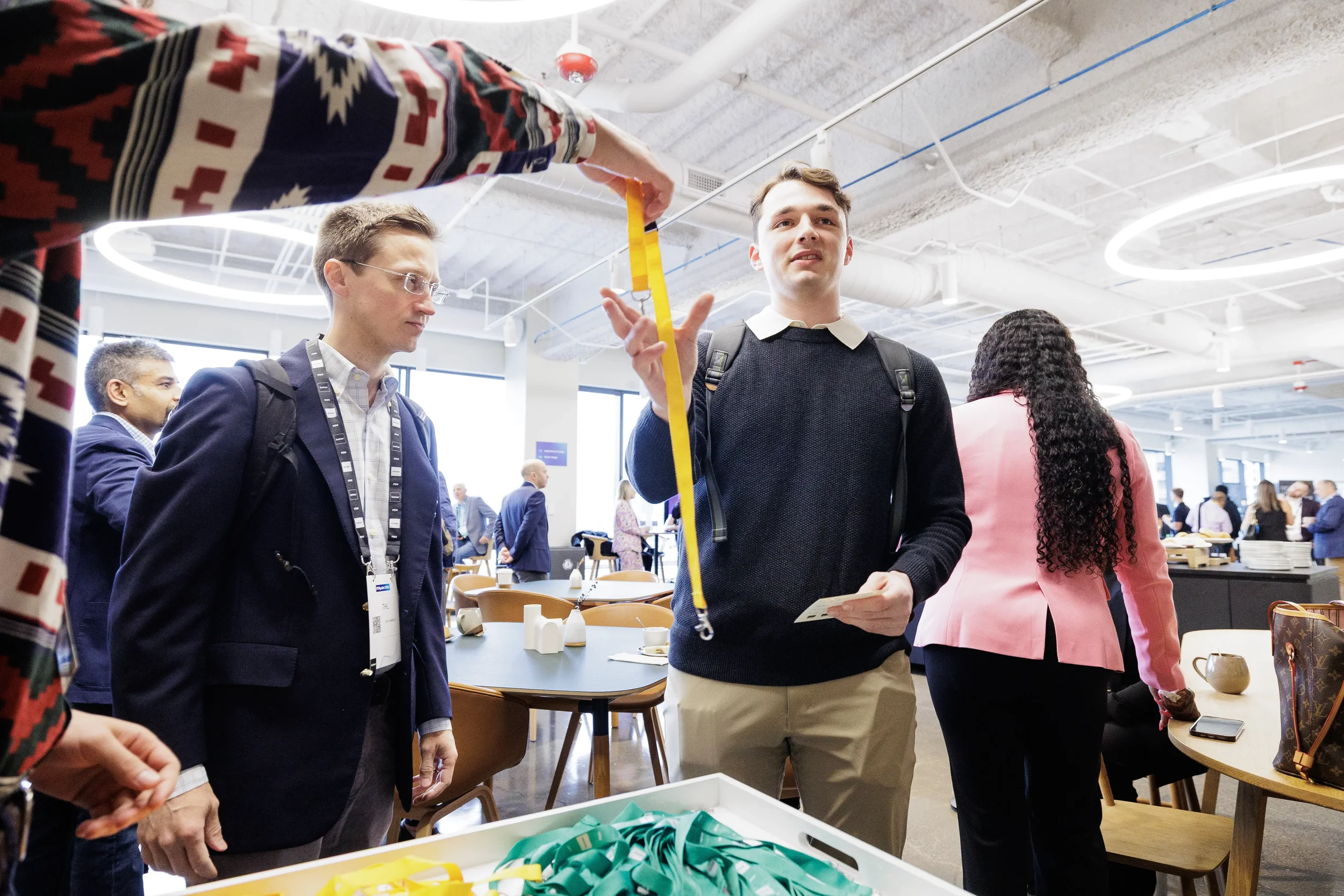 Registration staff hands yellow lanyard to arriving attendee at Chicago industry conference check-in