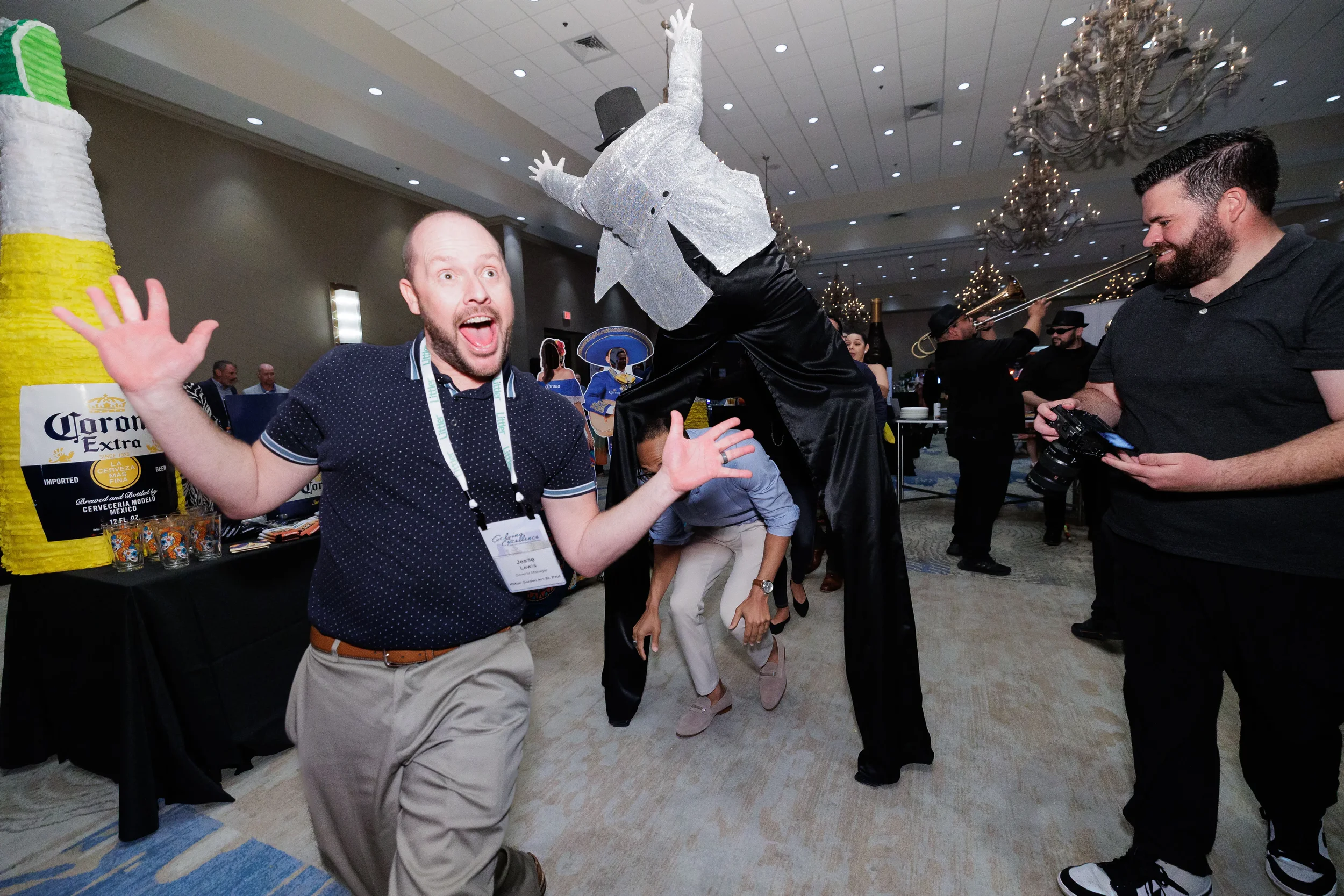 Excited attendee with lanyard reacts to stilt performer on Orlando corporate conference expo floor