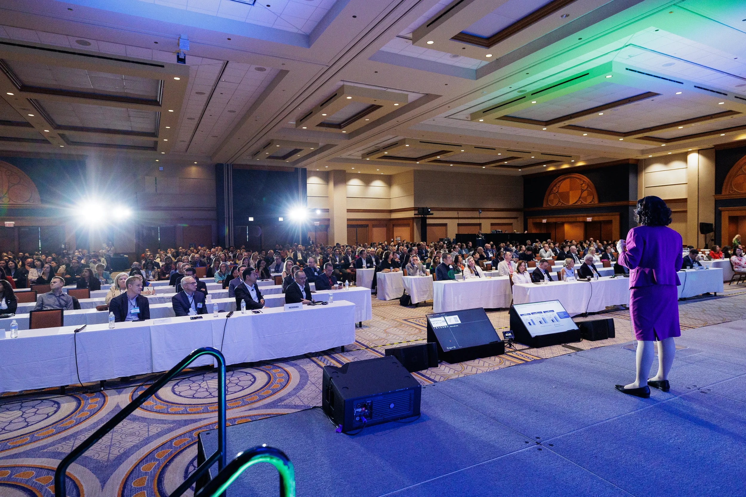 Speaker presents to seated audience during general session at Orlando corporate conference