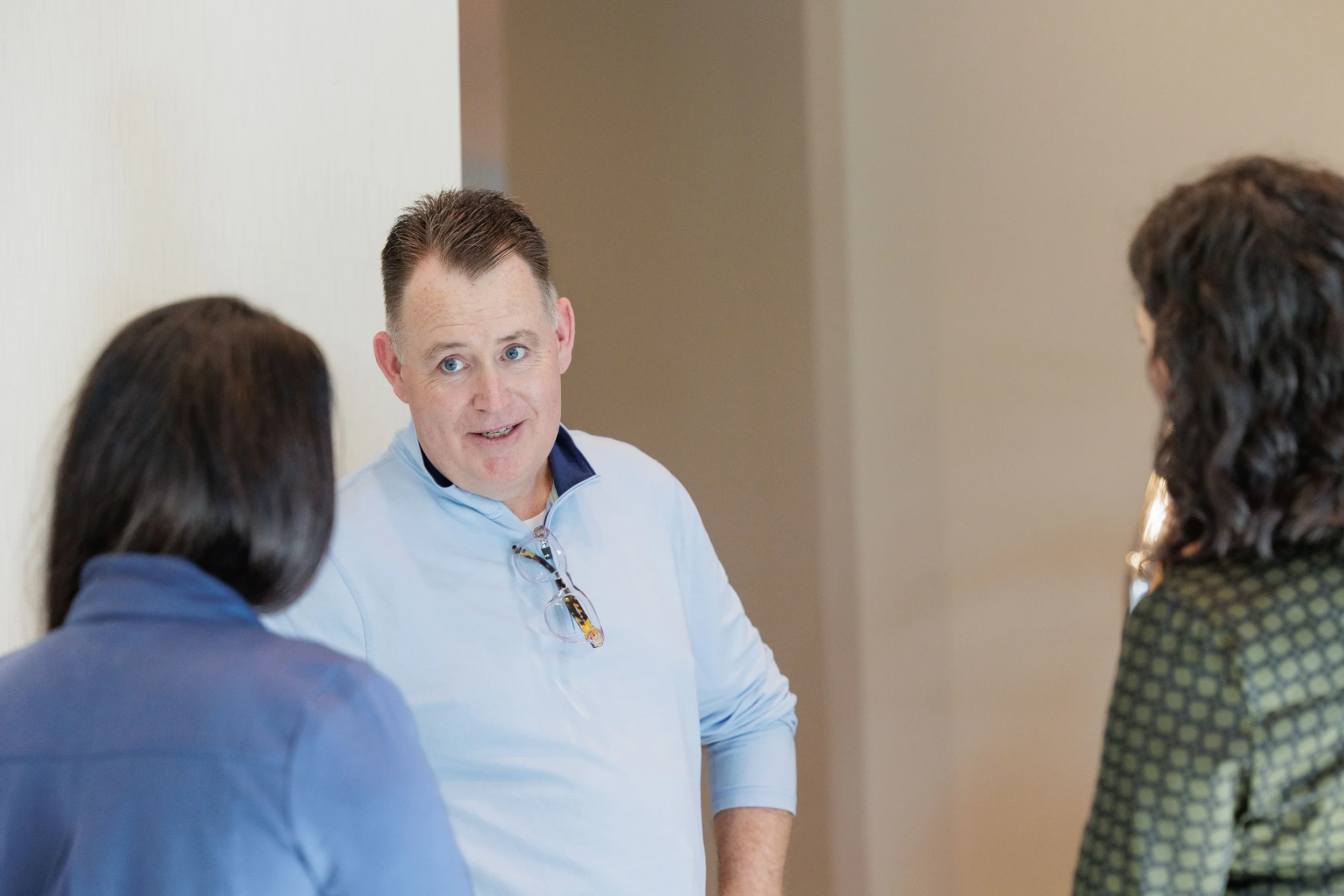Three attendees engage in conversation during networking break at Chicago corporate conference