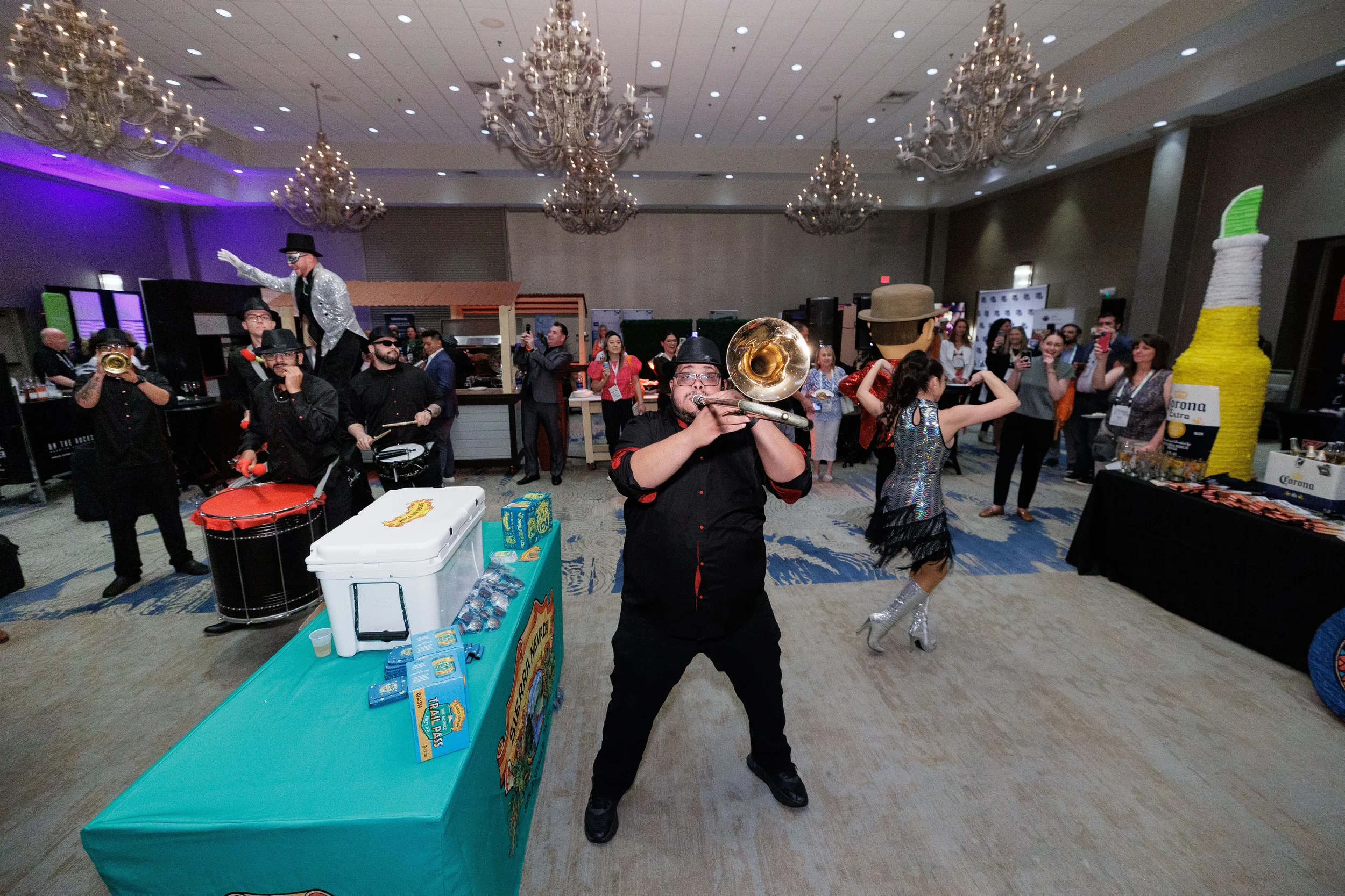 Brass band musician performs alongside stilt walker and dancers in ballroom at Orlando corporate event gala
