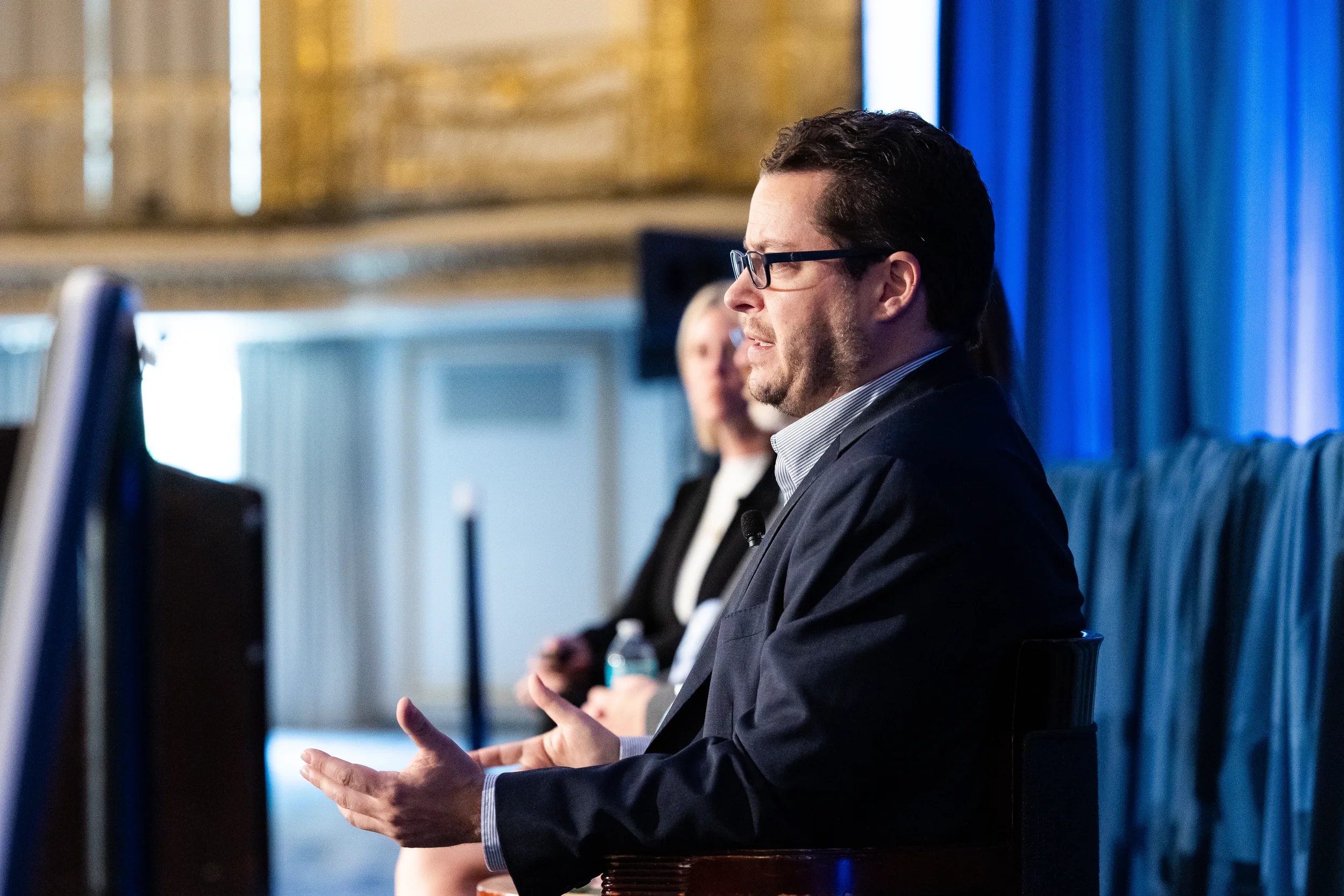 Panelist gestures while speaking during discussion at AACE International conference in Chicago