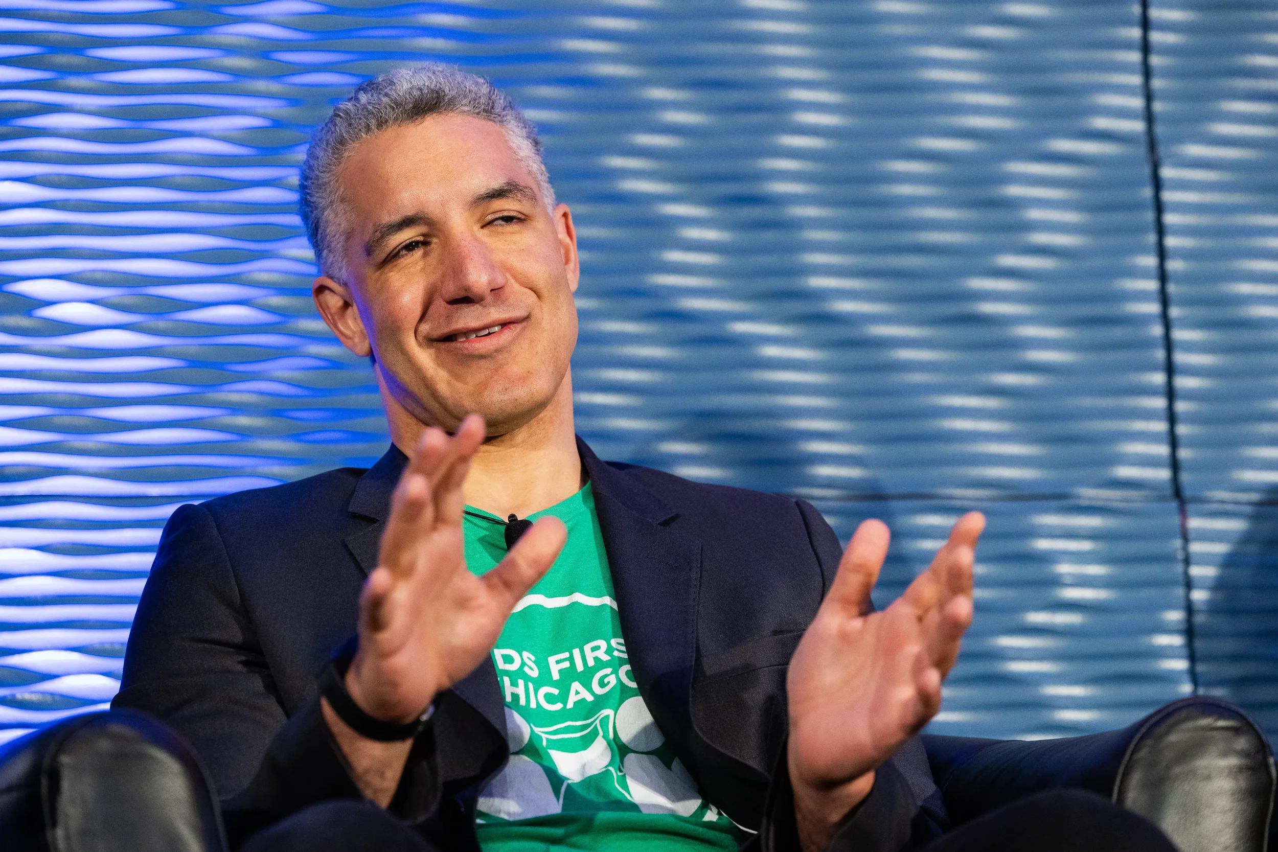 Panelist claps while smiling during fireside chat session at Orlando industry conference