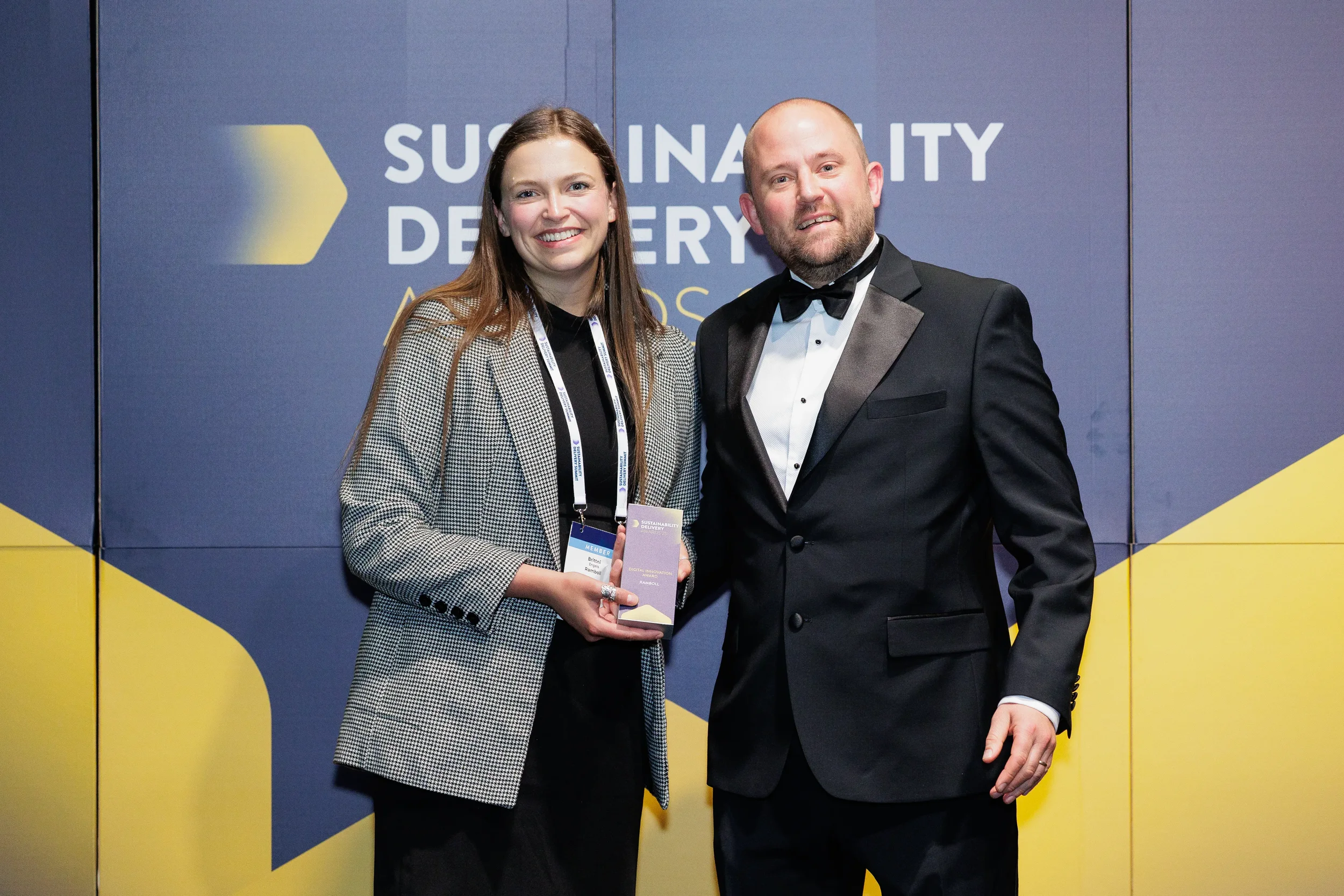 Award recipients pose with trophy in formal attire at Chicago corporate conference awards event