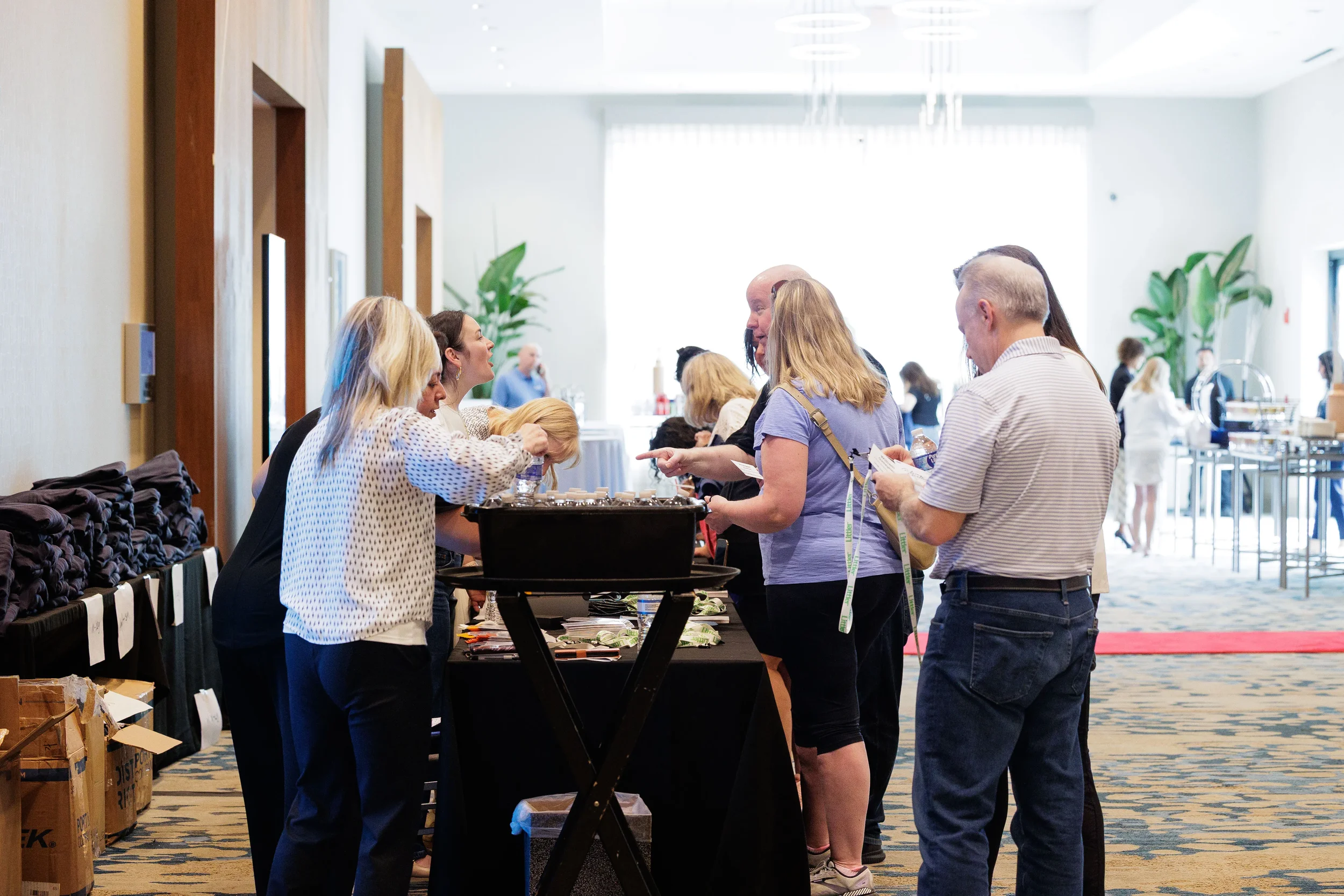 Group of attendees gather around activity table in bright Chicago corporate conference foyer