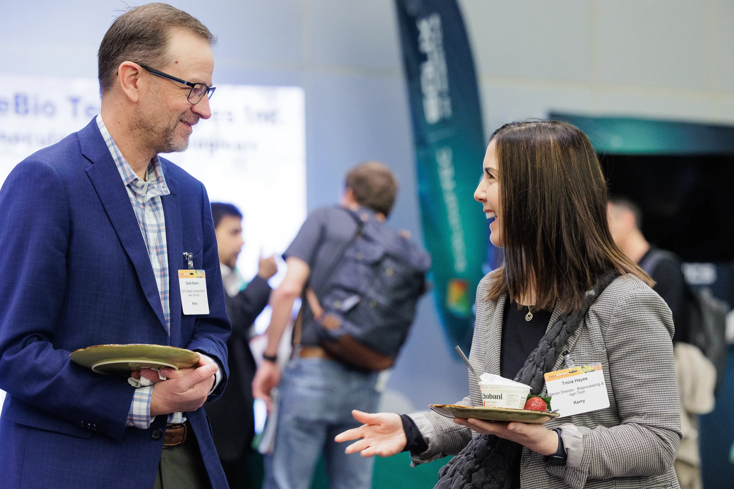 Attendees converse while holding plates of food during Orlando networking reception