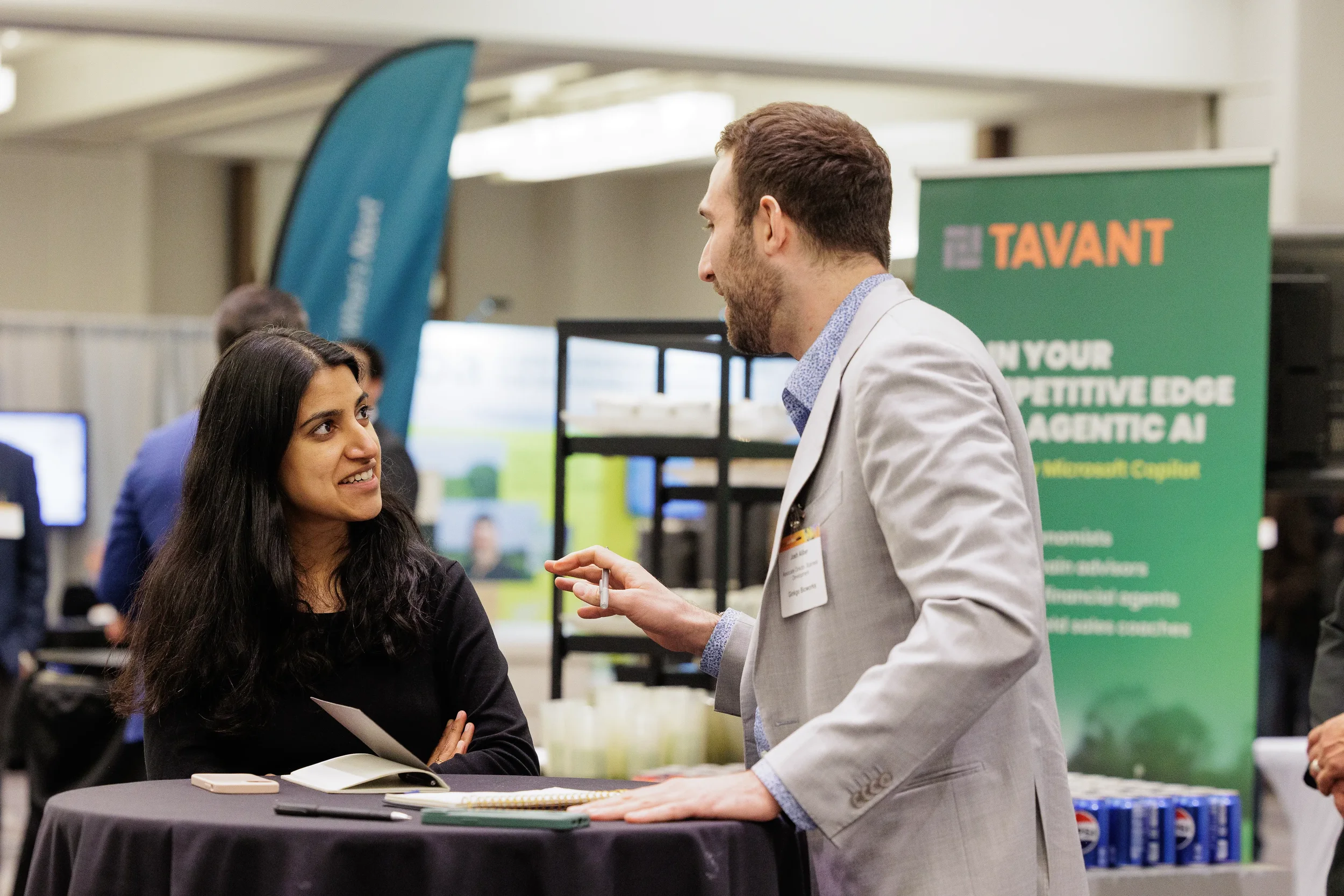 Attendee and exhibitor in engaged conversation at trade show booth during Orlando industry conference