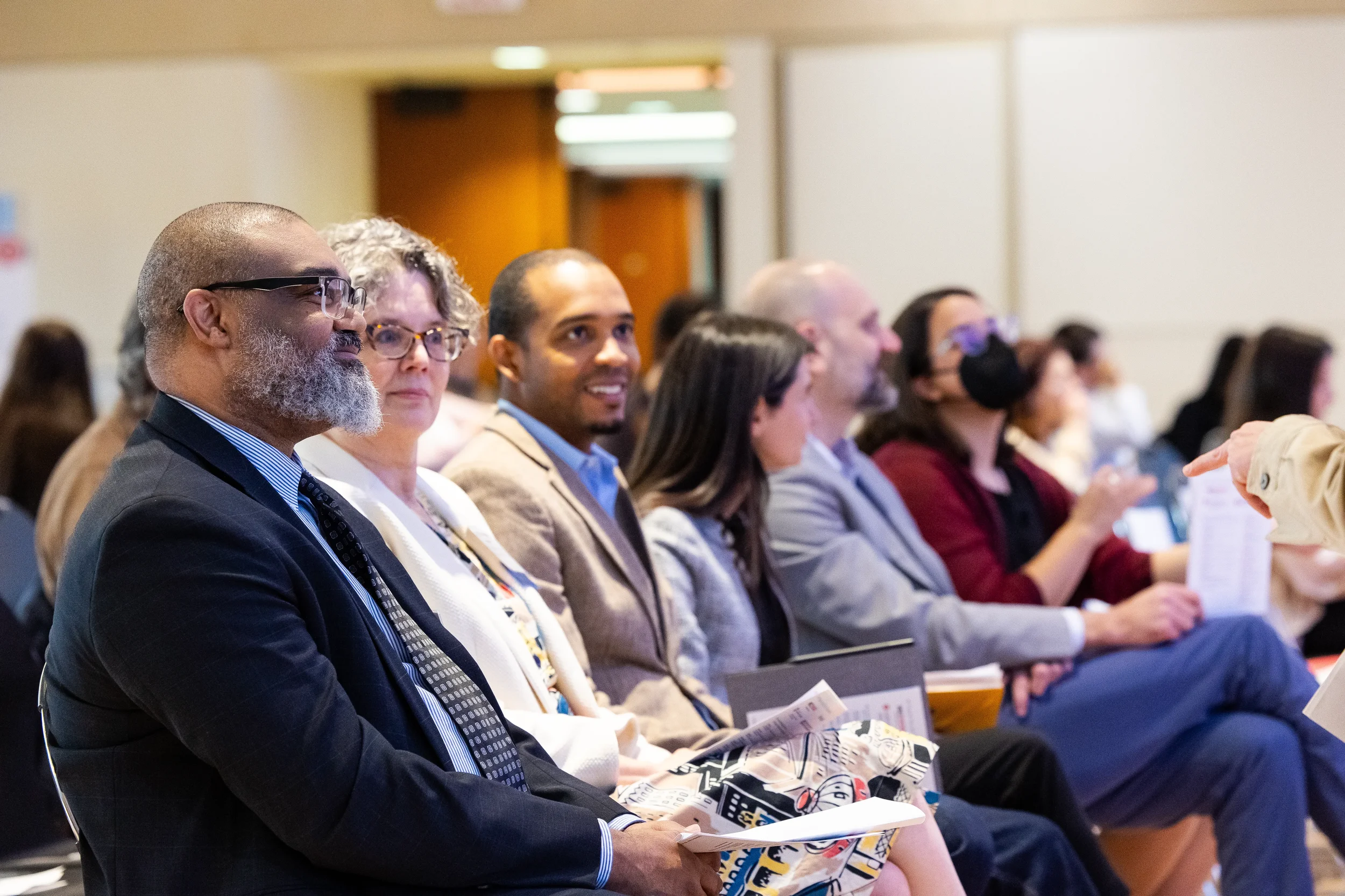 Attendees seated in audience rows listen attentively during session at Chicago corporate conference