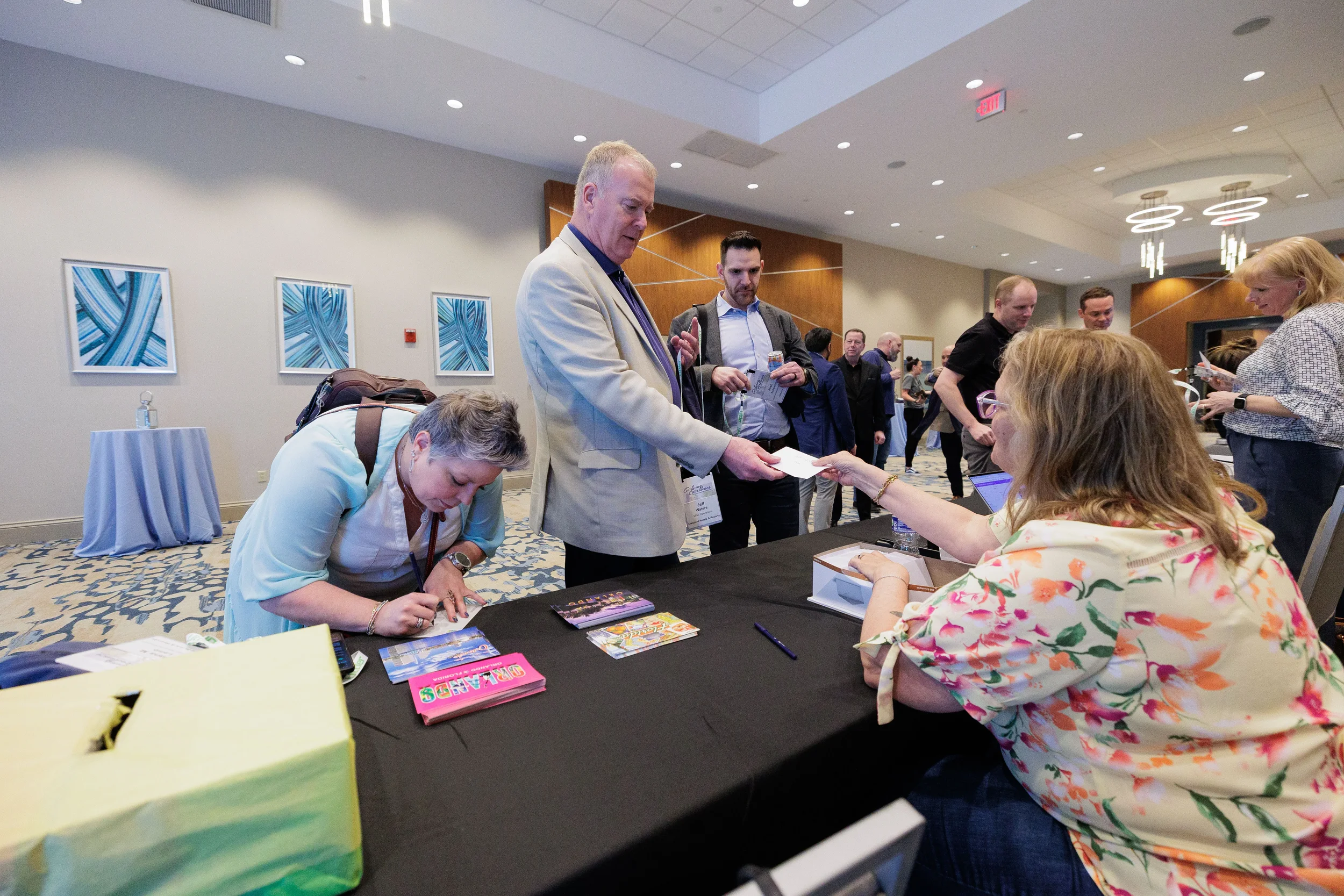 Attendees check in at registration table with lanyards and materials at Orlando corporate conference