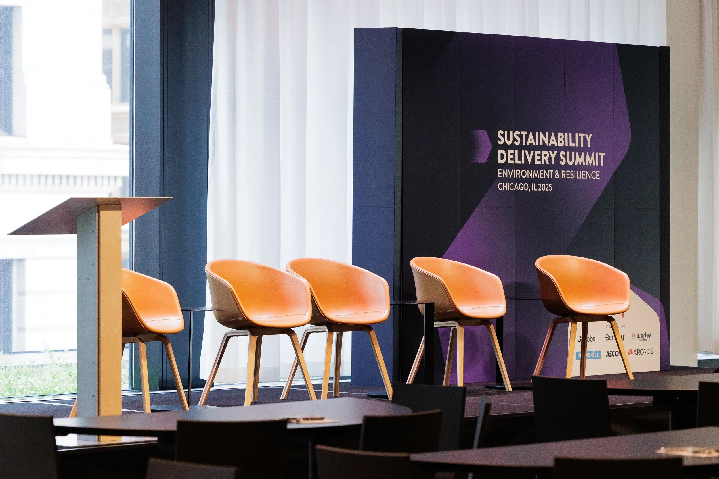 Empty stage setup with orange armchairs and podium ahead of Orlando corporate conference session