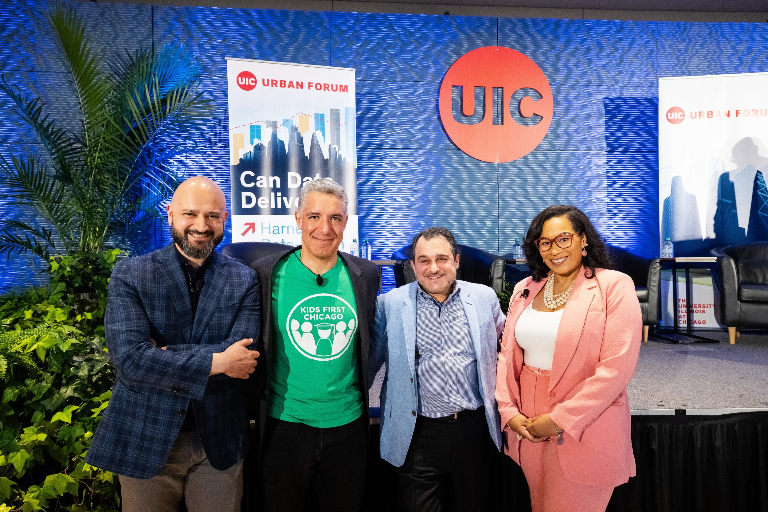Group of speakers pose together smiling on stage after panel at Orlando industry conference