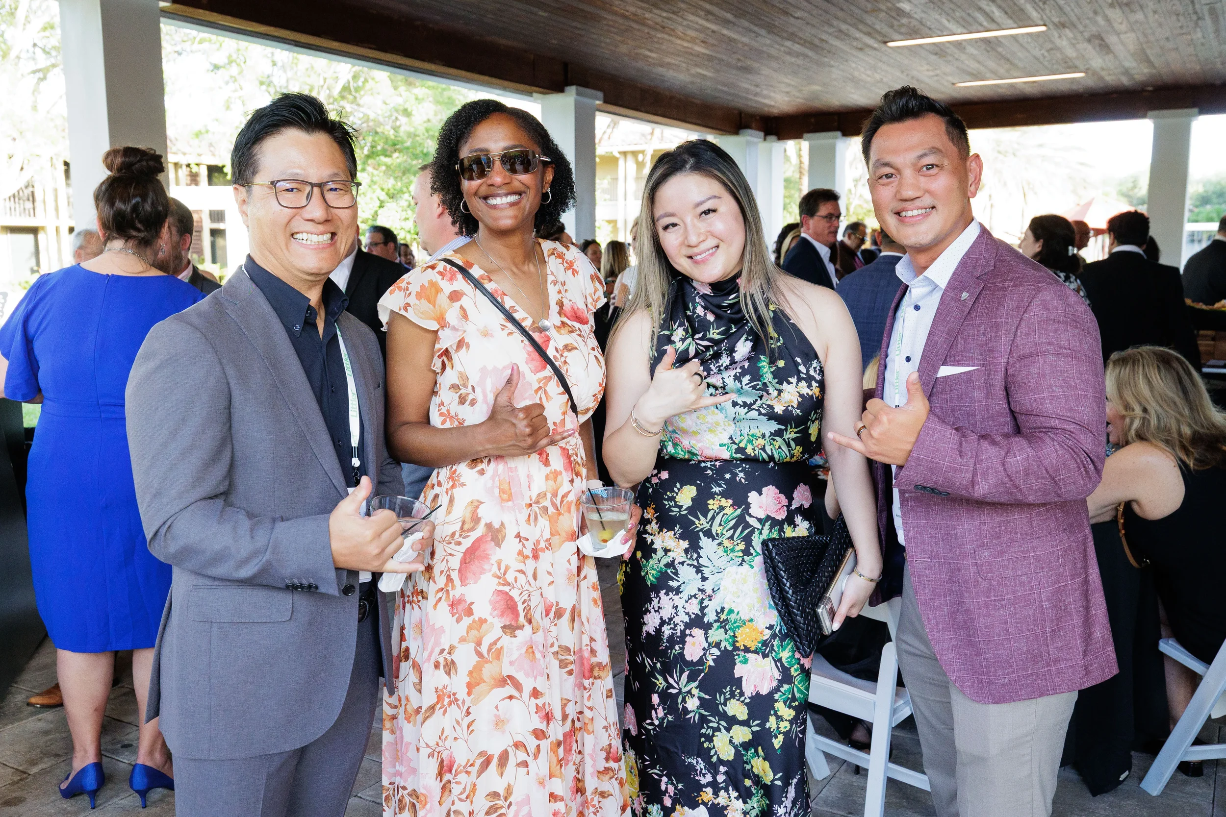 Four smiling attendees pose together at outdoor evening reception at Orlando corporate conference