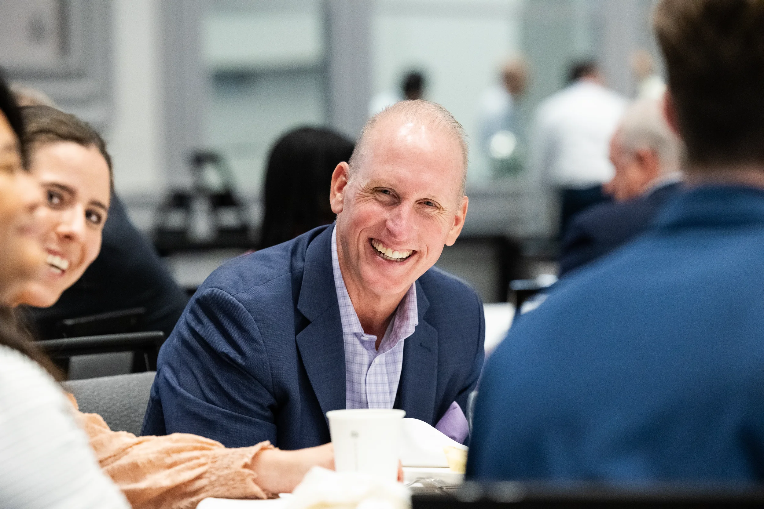 Conference attendee laughs during table conversation at Orlando corporate event