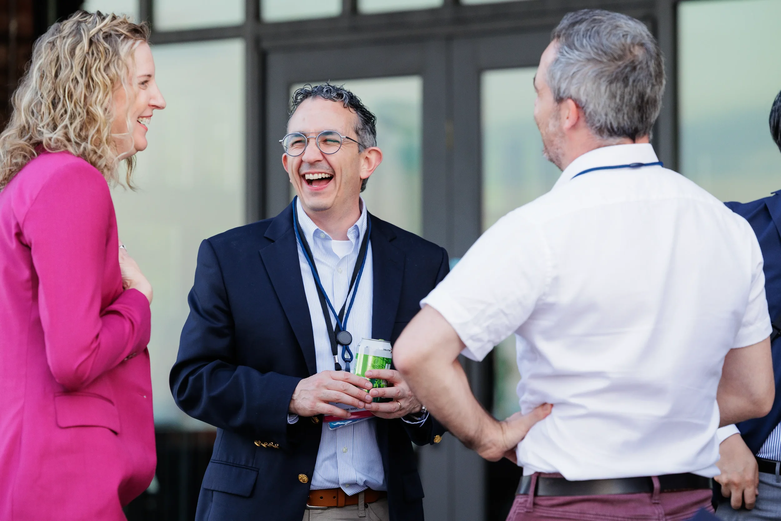 Attendees laugh while networking outside building entrance at Chicago corporate event