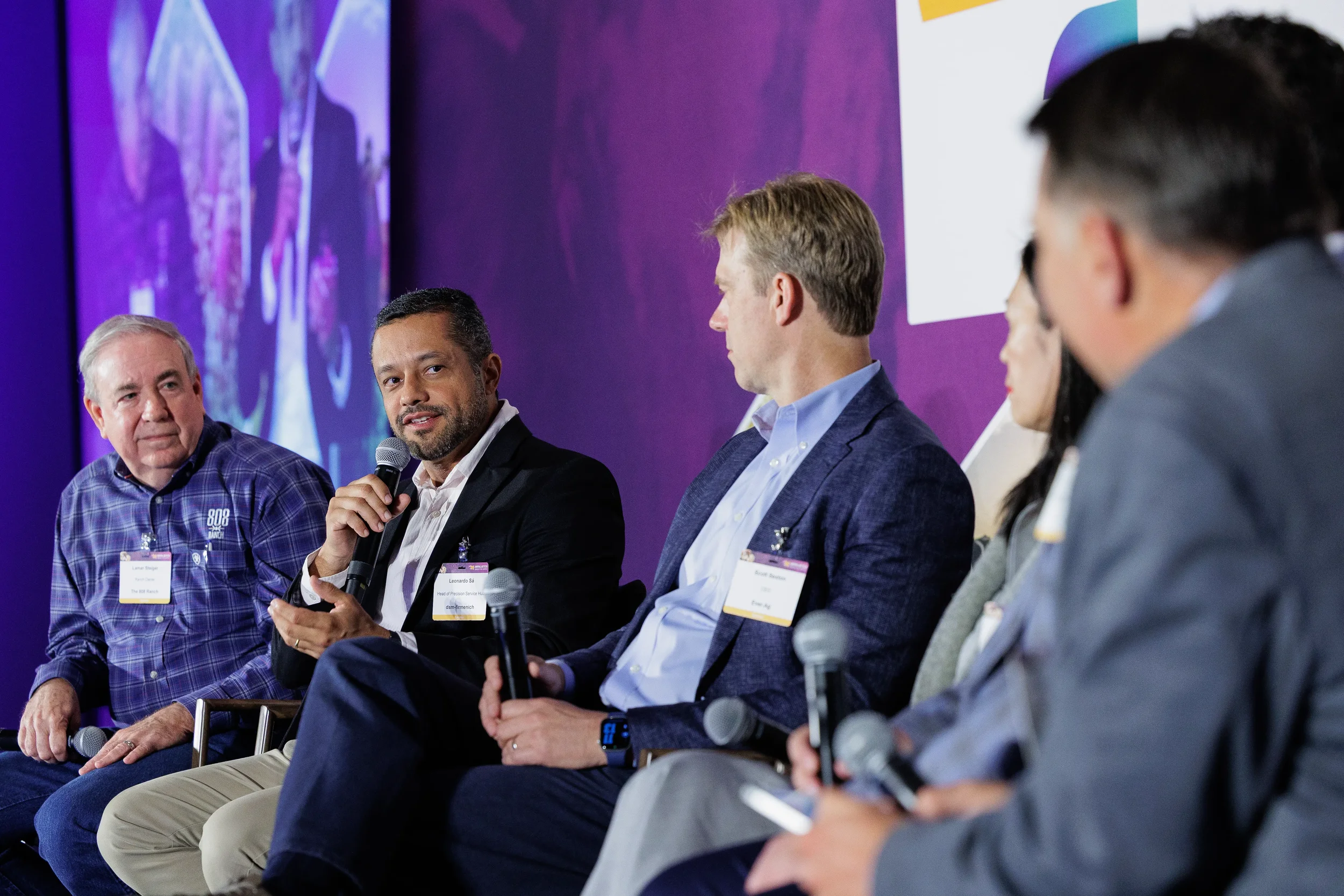 Panelist gestures while speaking on stage during panel discussion at Orlando corporate summit
