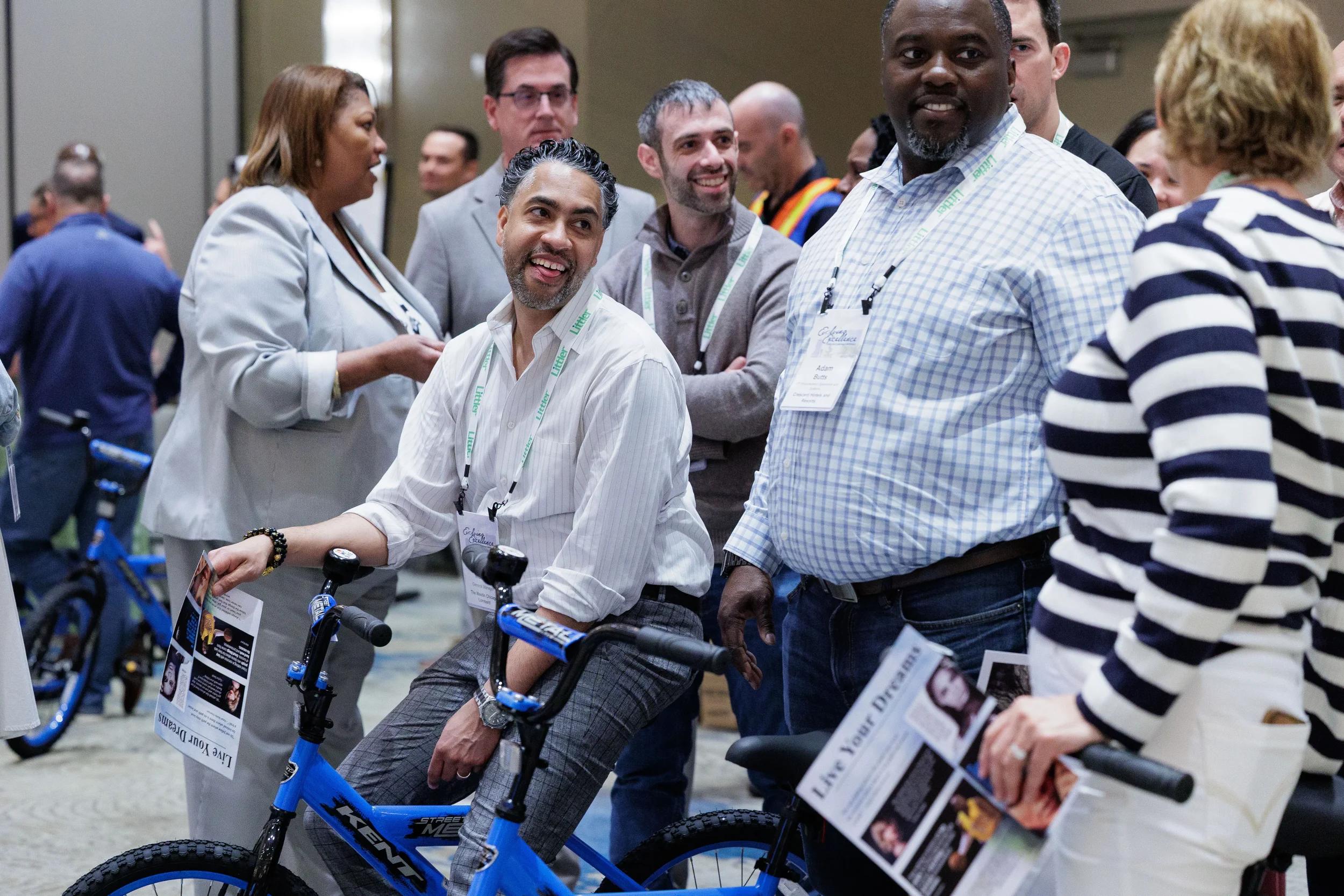 Attendees with lanyards pose with assembled bicycles during team activity at Chicago corporate event