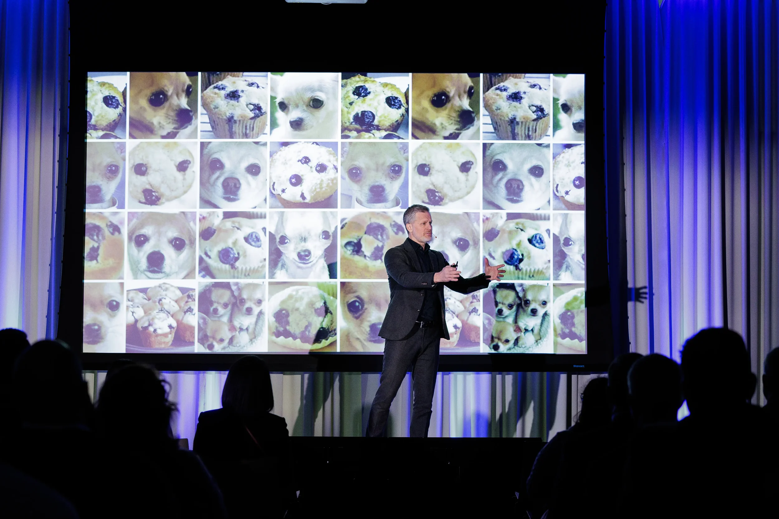 Speaker gestures on stage in front of photo grid slide with audience silhouettes at Chicago industry conference
