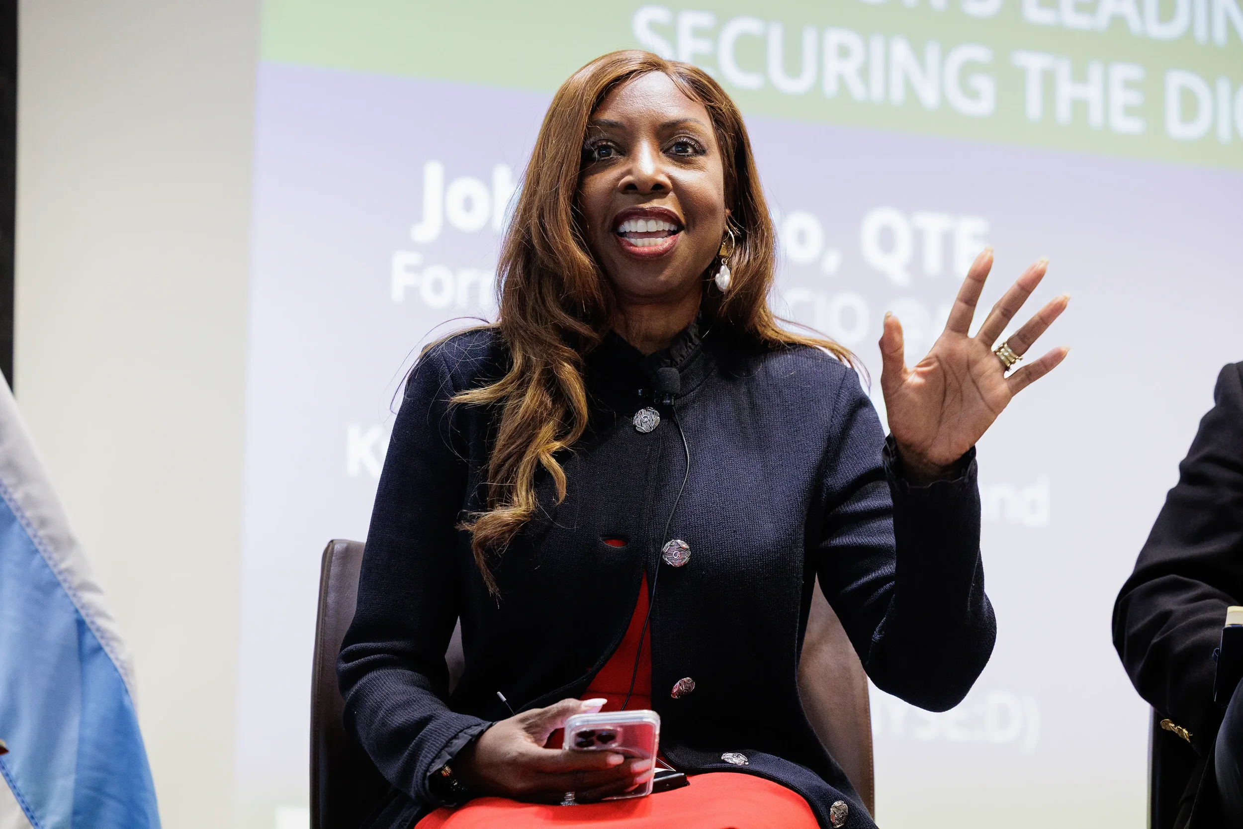 Female panelist waves hand expressively while speaking during panel discussion at Chicago industry conference