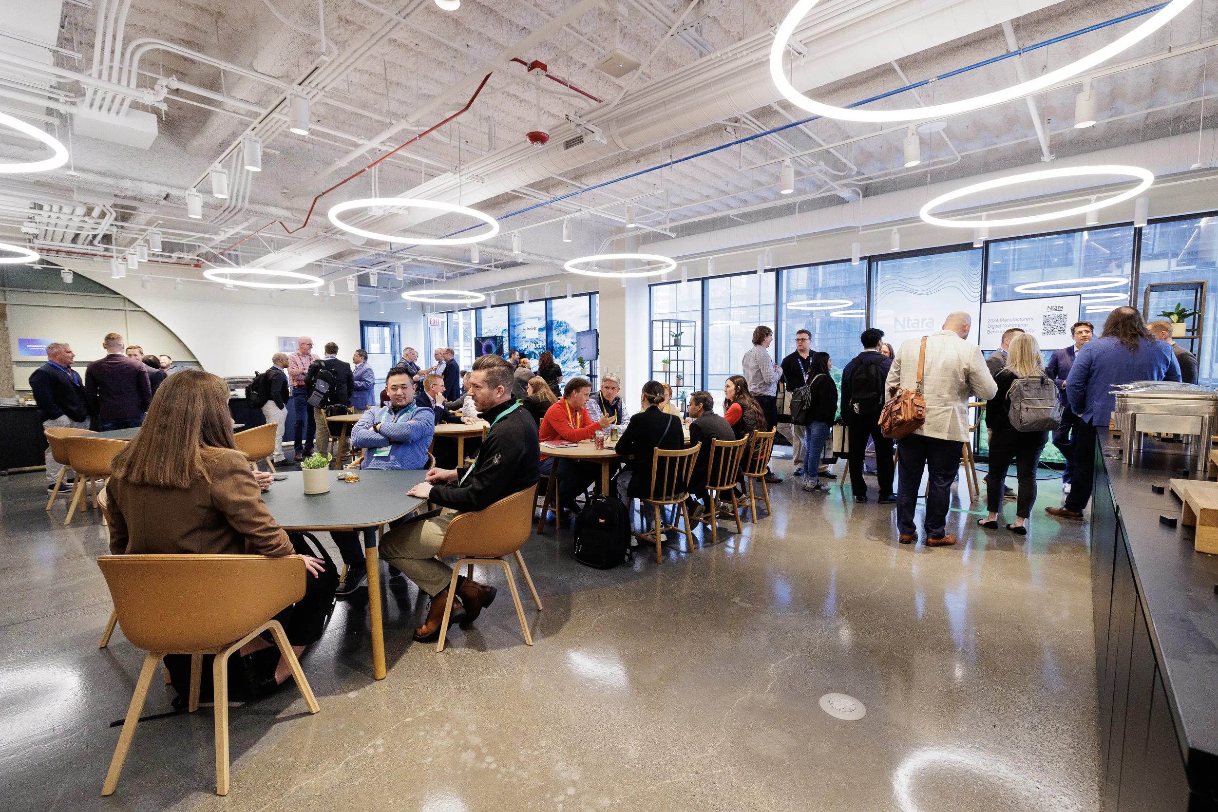 Attendees network at lounge tables beneath ring lights during Chicago corporate conference reception