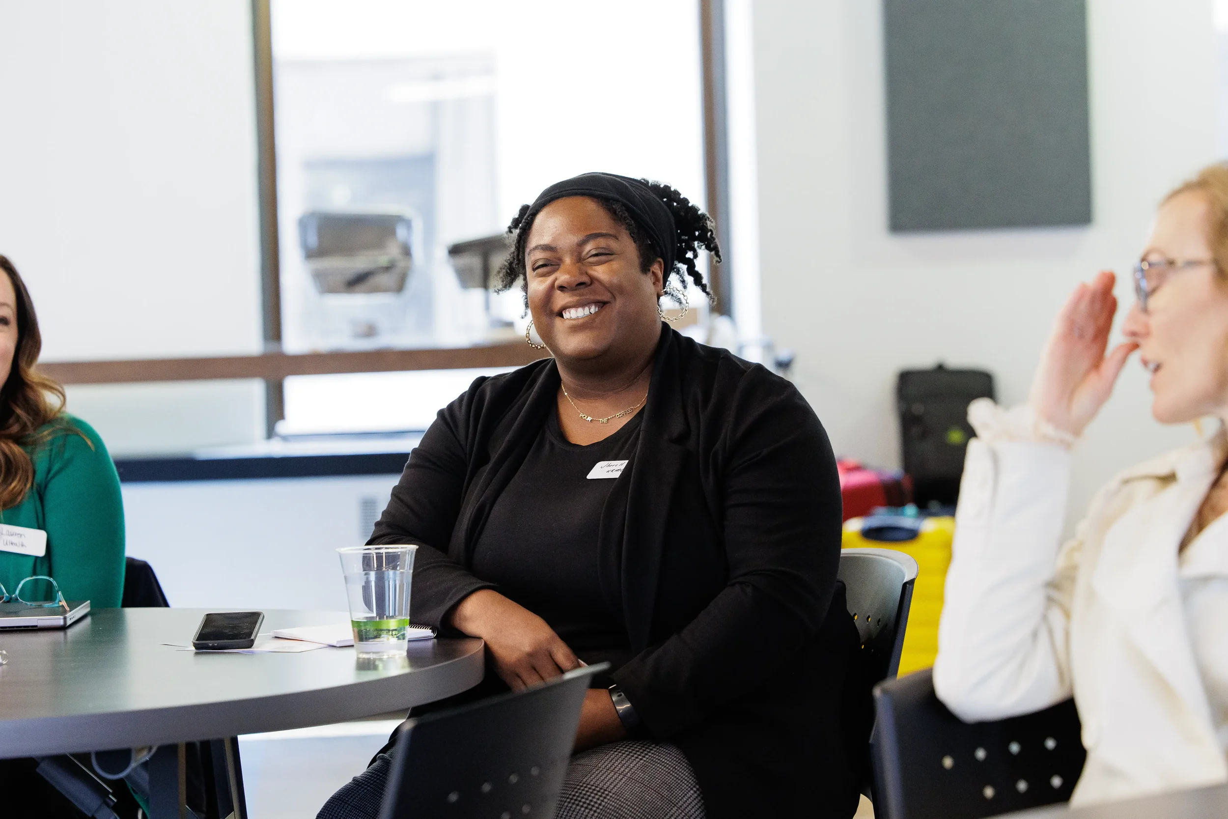 Female attendee laughs broadly at a table while fellow attendees react during Orlando corporate event