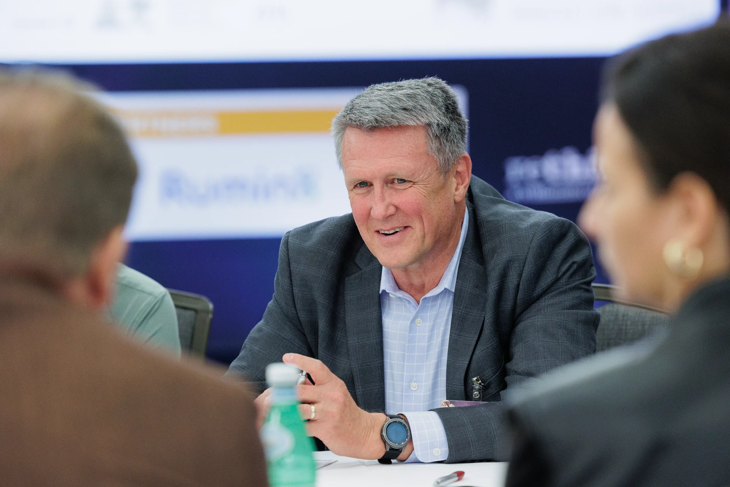 Attendee smiles while speaking during roundtable discussion at Orlando corporate conference