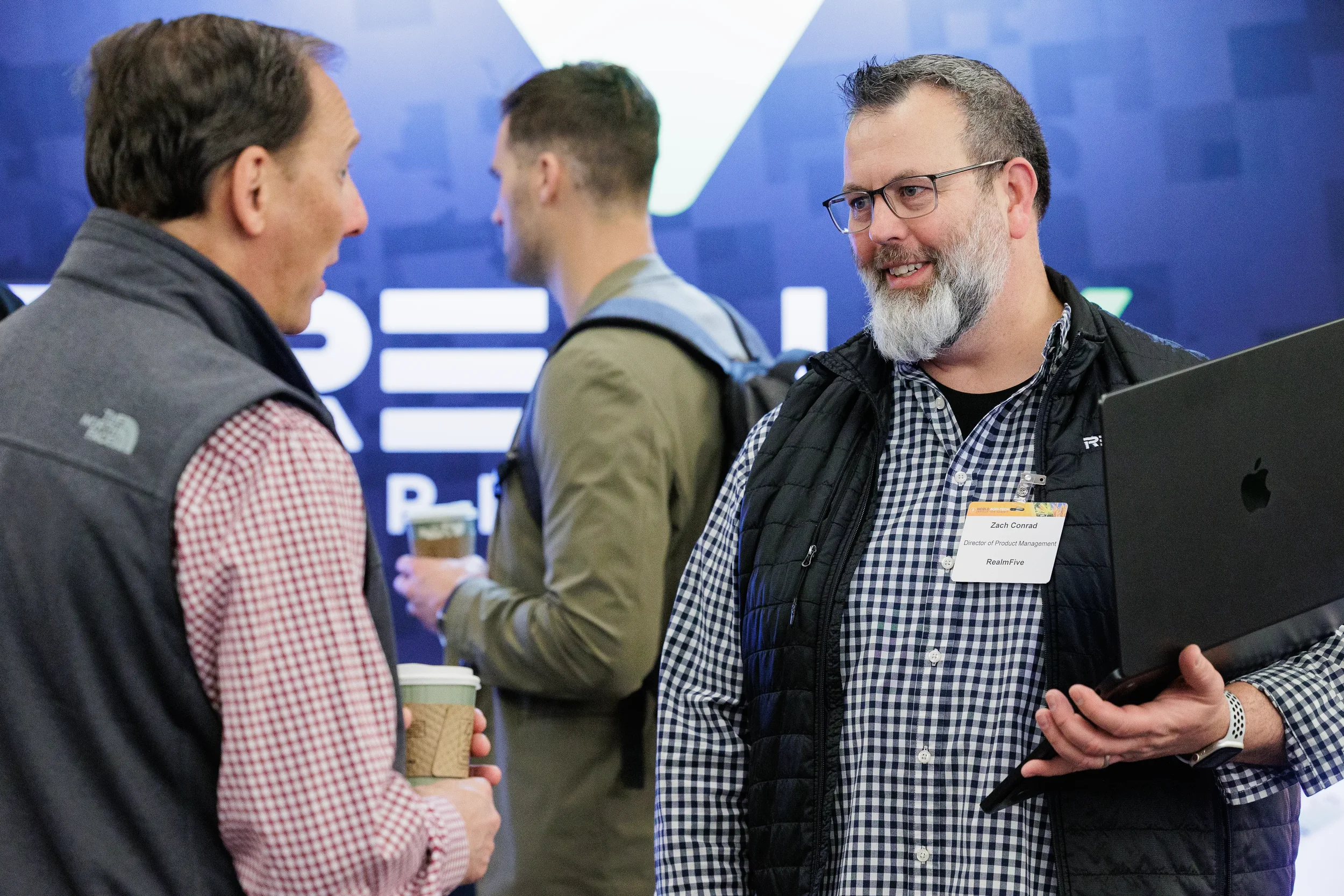 Attendees converse over coffee near sponsor booth at Chicago industry trade show