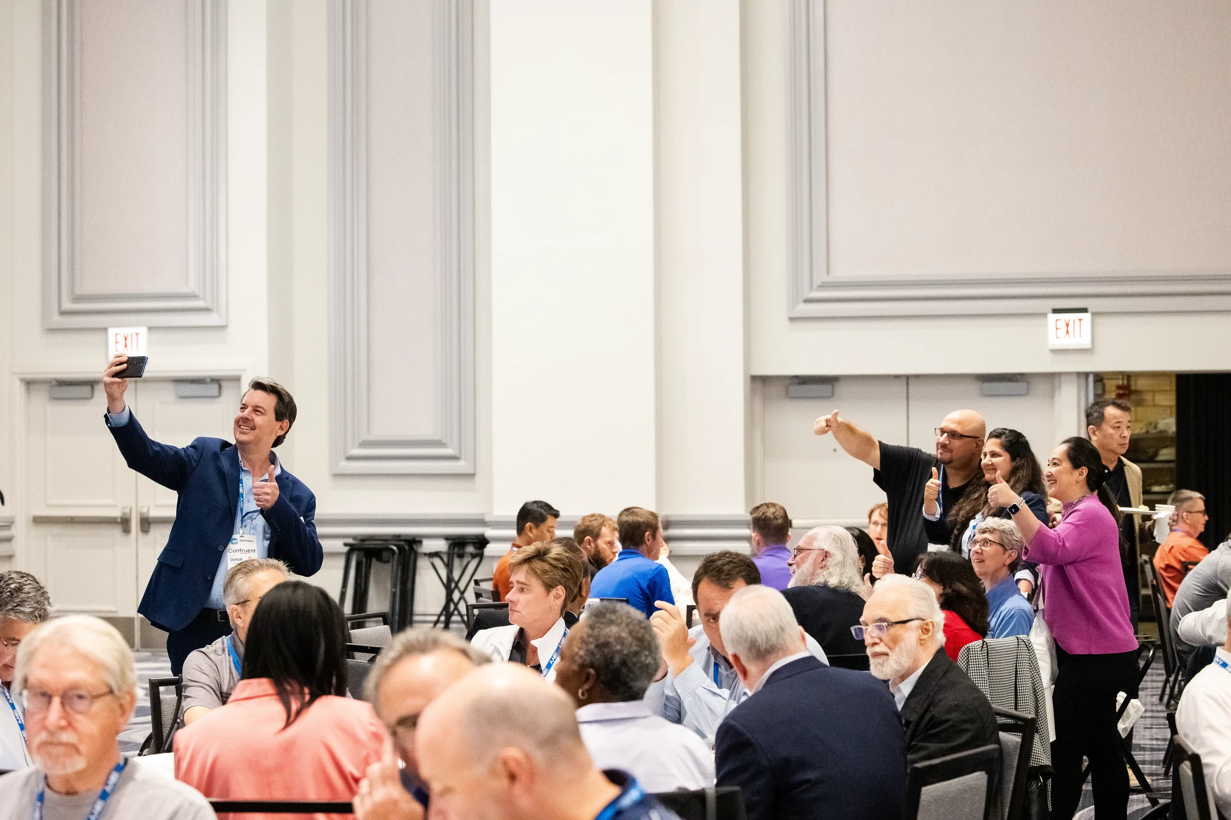 Enthusiastic attendees pose for group selfie moment during conference session at Chicago corporate event