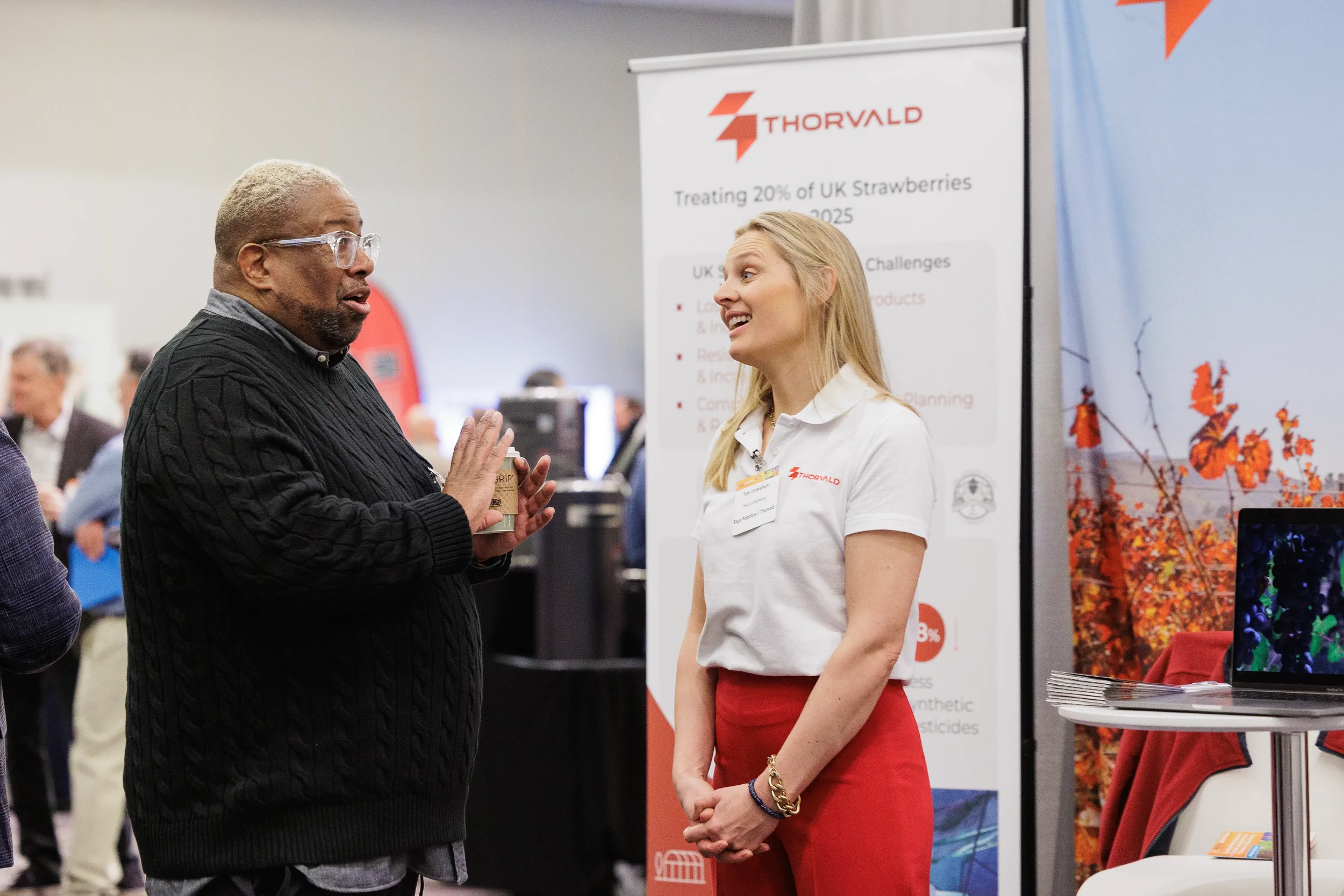 Attendee converses with badged exhibitor at trade show booth during Chicago corporate conference expo